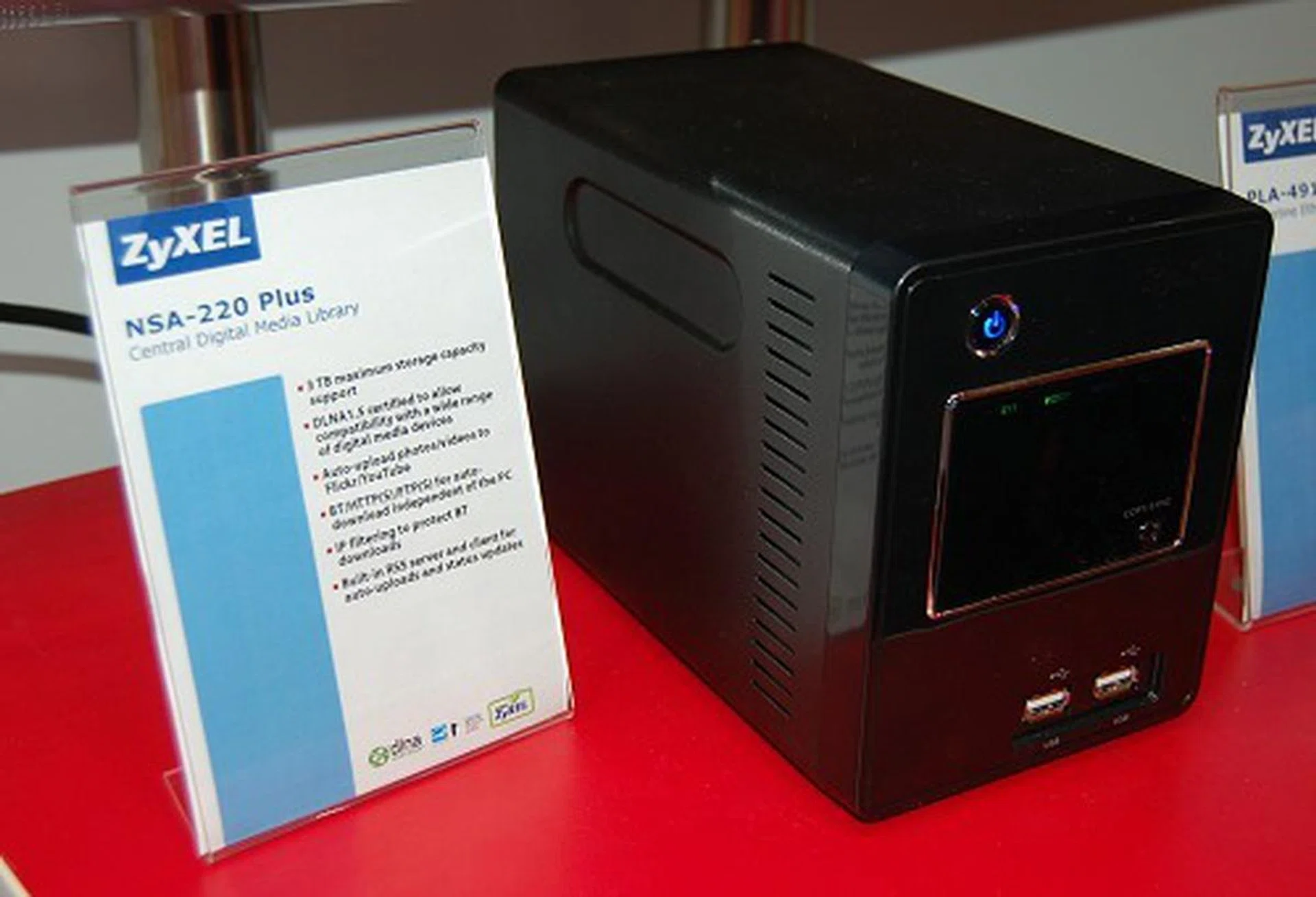  We were naturally more interested in the smaller scale devices such as this NSA-220 Plus, as Zyxel calls it, a central digital media library. This dual-bay device supporting a maximum of 3TB storage in total, is DLNA 1.5 certified, has auto photo/video upload functions to YouTube/Flickr if you so wish to do so, automatic downloading from BT, HTTP or FTP, and a built-in RSS server/client fro auto-uploads and status updates.  