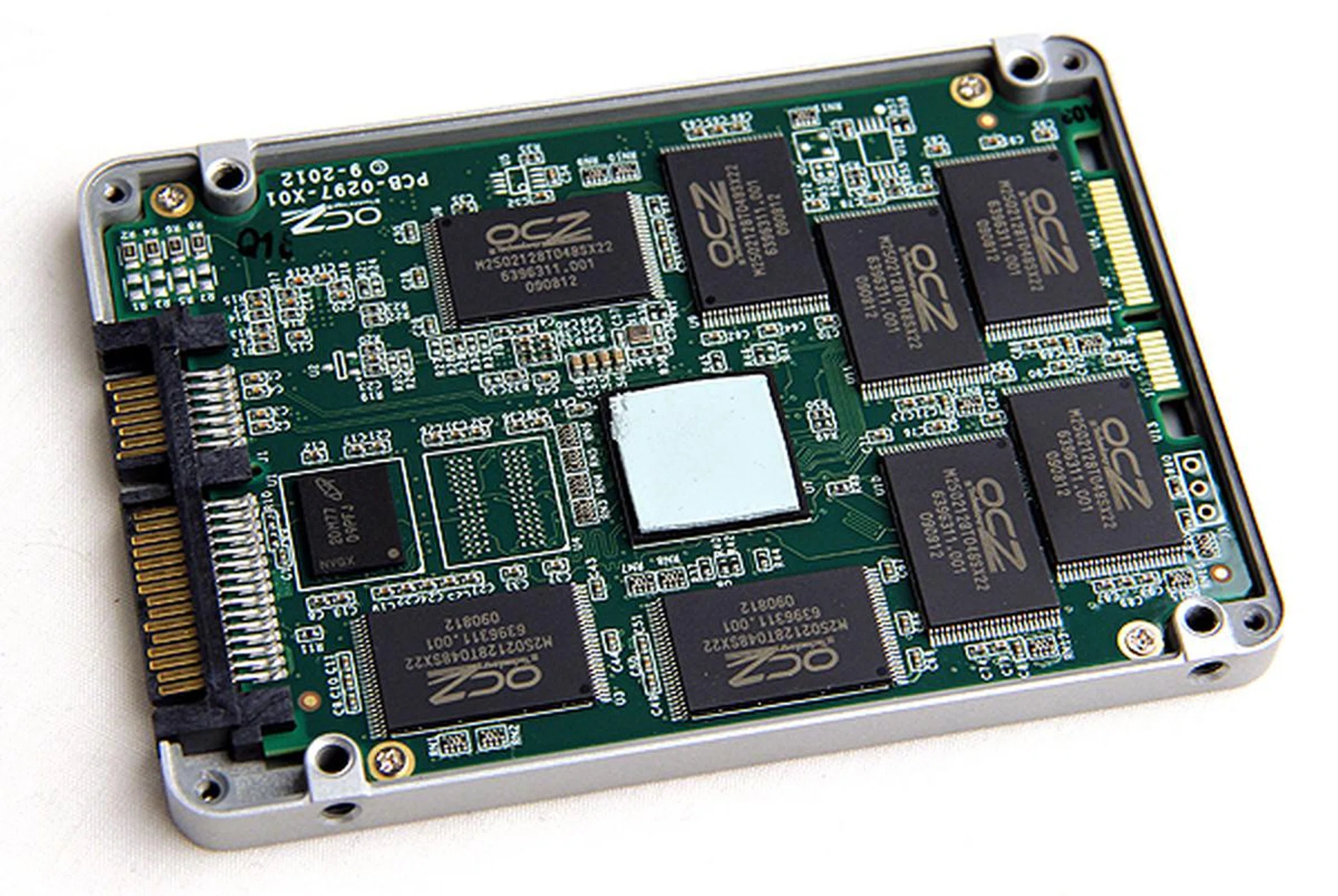 The new Indilinx Barefoot 3 controller (IDX500M00-BC) is concealed by a thermal pad. Surrounding it are eight NAND memory chips of 16GB density, OCZ-branded by actually supplied by IMFT. Finally, the smaller chip to the left of the controller is a 256MB DRAM chip from Micron.