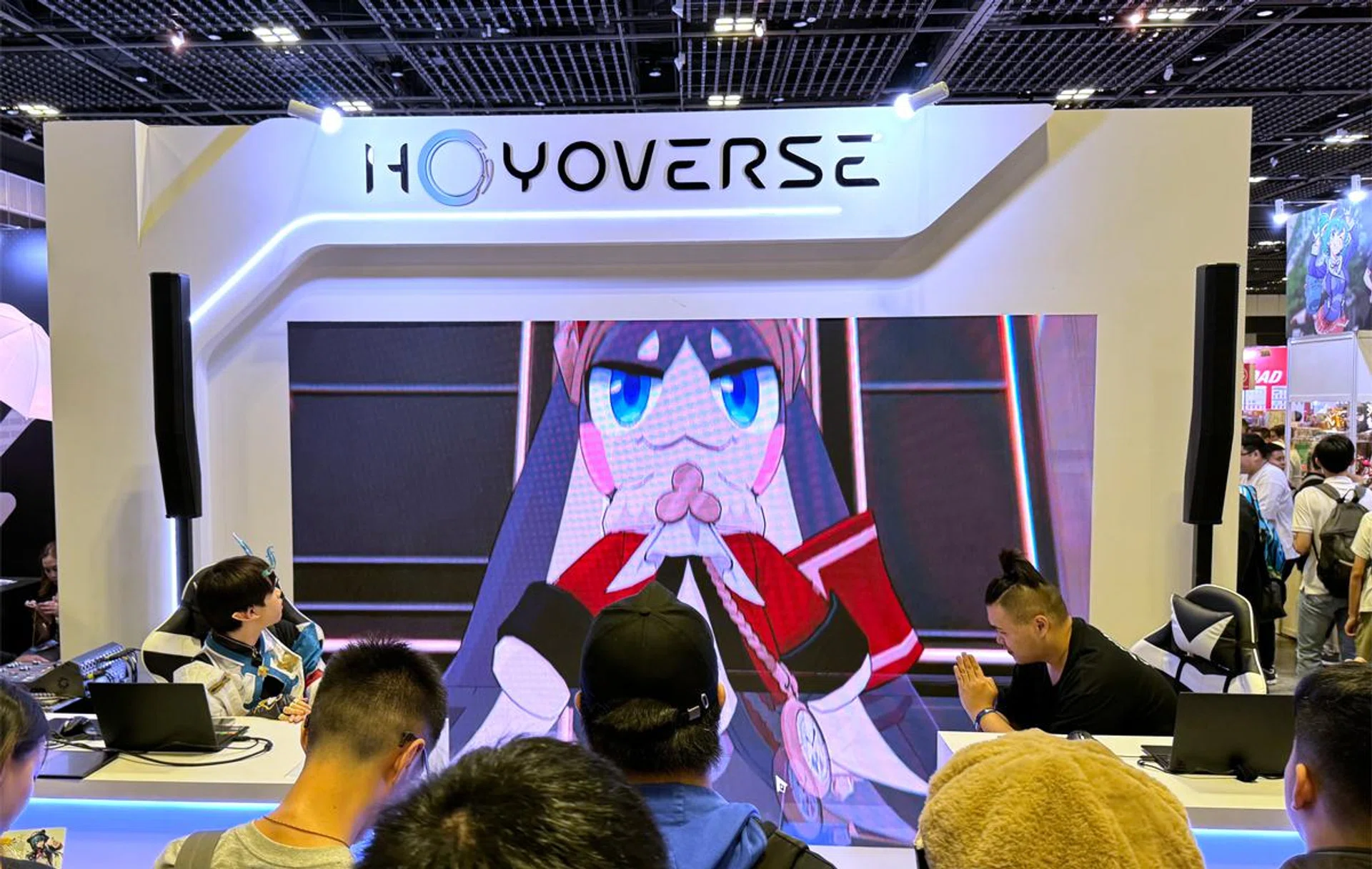 Competition stage at the HoYoVerse booth, next to Zenless Zone Zero.