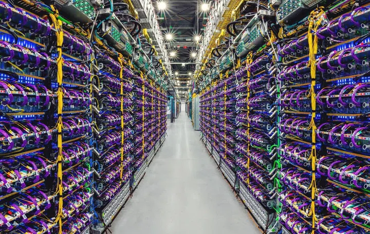 A row of Cloud TPU v5p AI accelerator supercomputers in a Google data centre. Image source: Google. 
