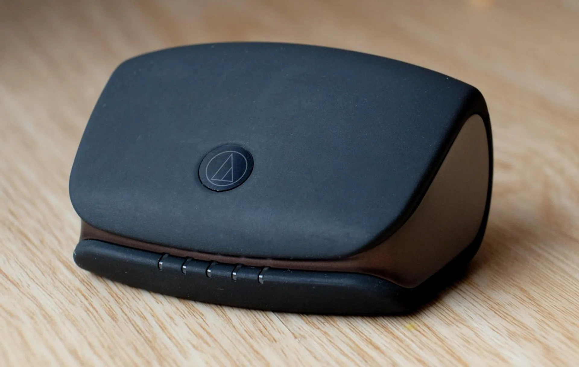 The charging case has an unusual shape and is covered in soft touch rubber. Though nice to the touch, it does trap dust easily.