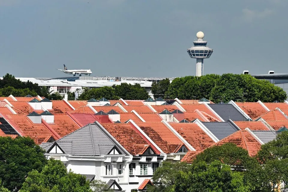 Image of an airplane landing with the Changi Control Tower in the background.