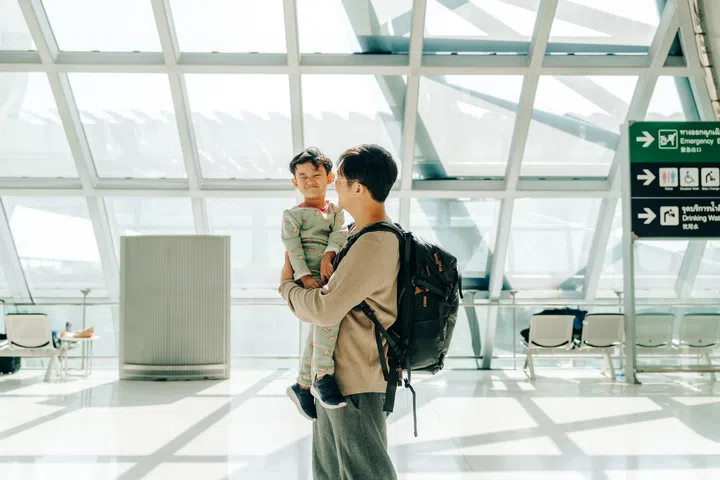Father comforting his son at the airport, sharing a heartwarming travel moment