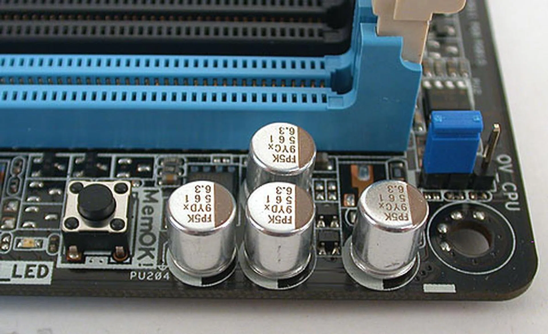 A closer look reveals that location of ASUS' MemOK! feature and near that, a blue jumper that can extend the maximum limit on voltages in the BIOS when enabled.