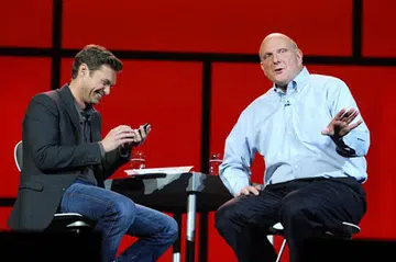 Microsoft CES Keynote host Ryan Seacrest checks out Steve Ballmer's Windows Phone.