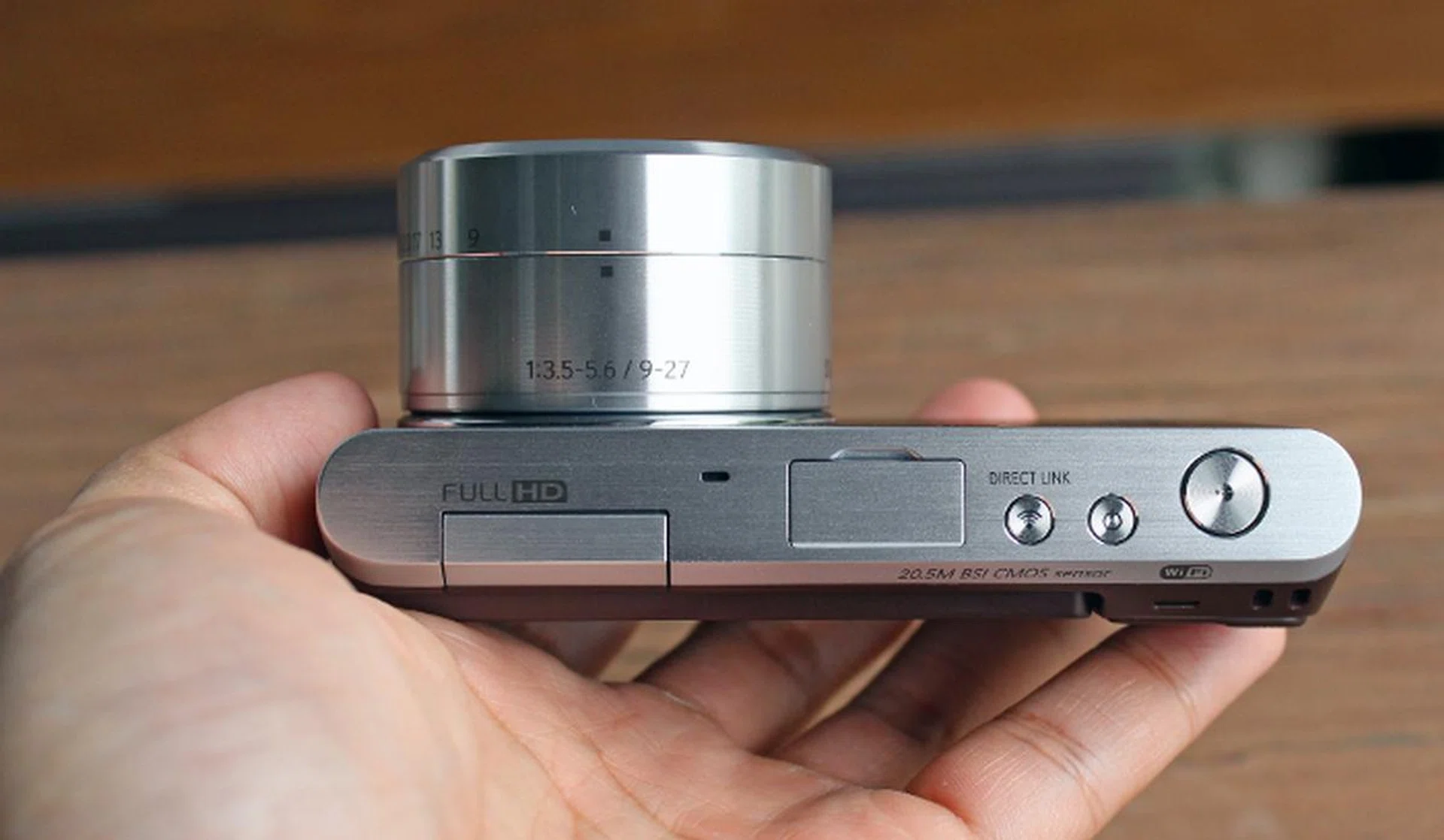The NX Mini is one of the smallest mirrorless system cameras around. Pictured here, it's paired with a NX-M 9-27mm F3.5-5.6 ED OIS lens. If you mount the default 9mm F3.5 pancake lens, its lens barrel would be far more compact.