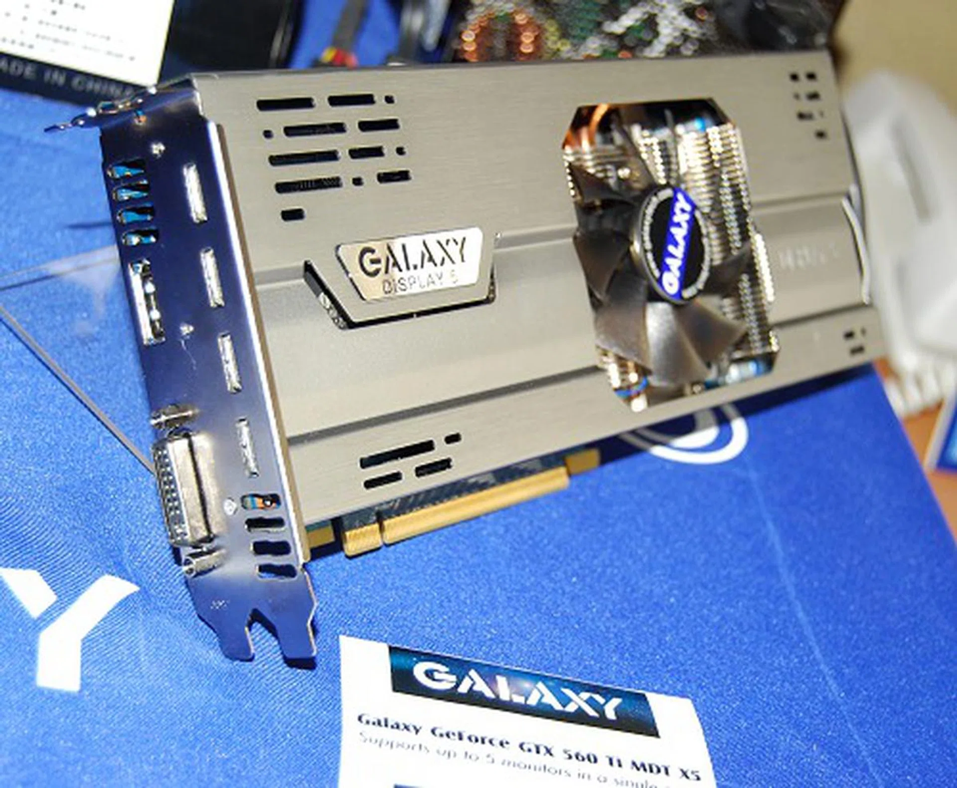 A standard GeForce graphics card can only support two monitor outputs. However, the Galaxy GeForce GTX 560 Ti MDT X5 supports up to 5 displays. It does this by integrating an IDT VMM1400 multiplier chip for a pure hardware solution to drive four more displays via HDMI in addition to the fifth driven by the GPU directly. The four monitors driven by the IDT chip support a max resolution of 1440 x 900 in quad-monitor mode, or 1680 x 1050 in tri-monitor mode. Note that the extra sized card is due to an added daughterboard of this added functionality.
