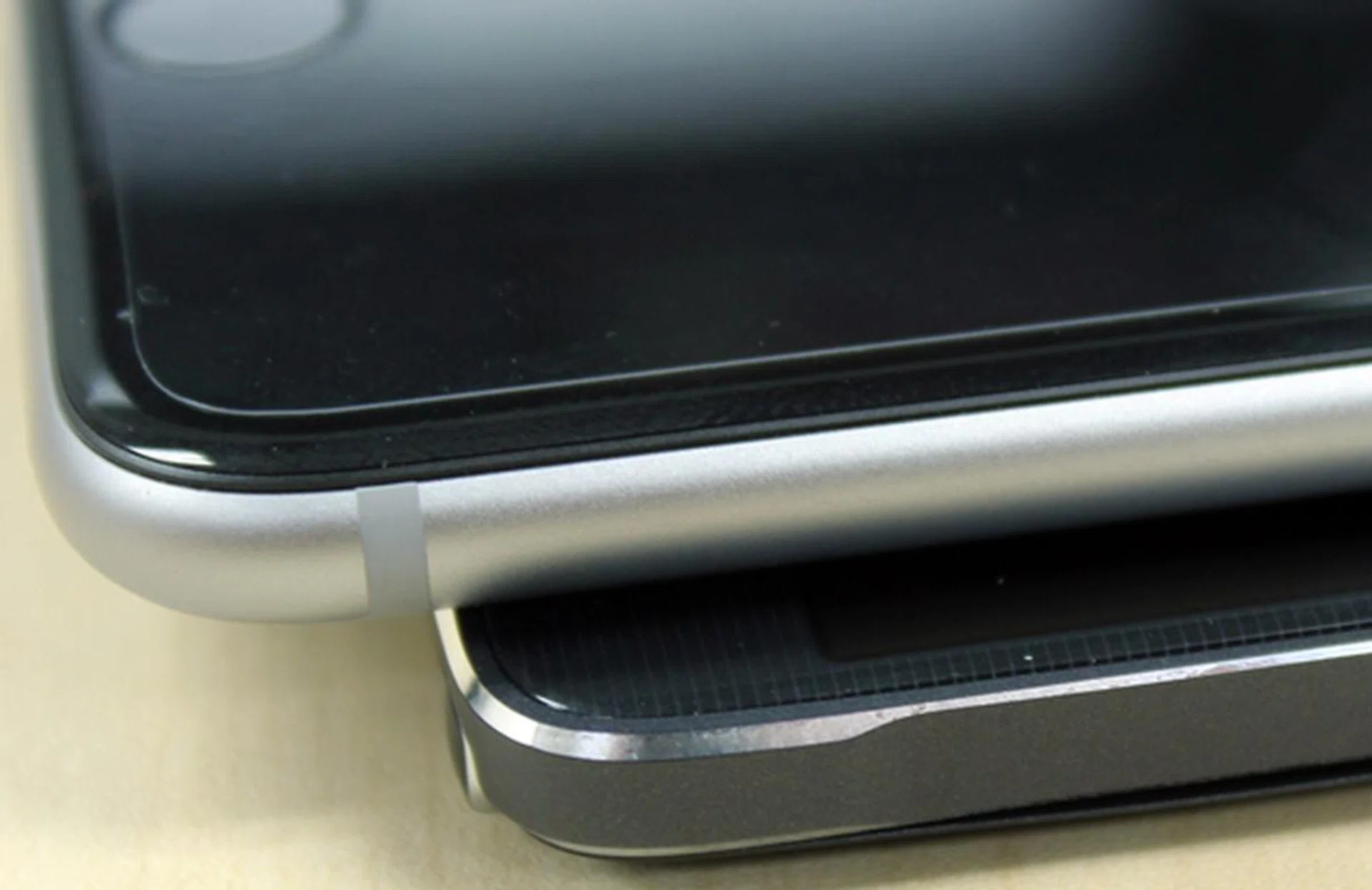 The touch screen experience is slightly better on the Apple iPhone 6 Plus (top) as the screen seamlessly joins the sides of the device.