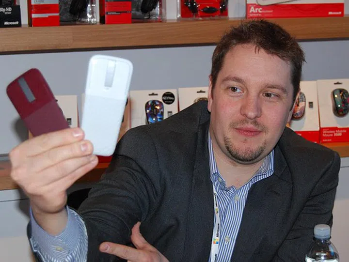 Ben Reed, Senior Manager for Microsoft Hardware holds out two more recently debuted limited edition Microsoft Arc Touch mice with color options like Cement Grey and Sangria Red.