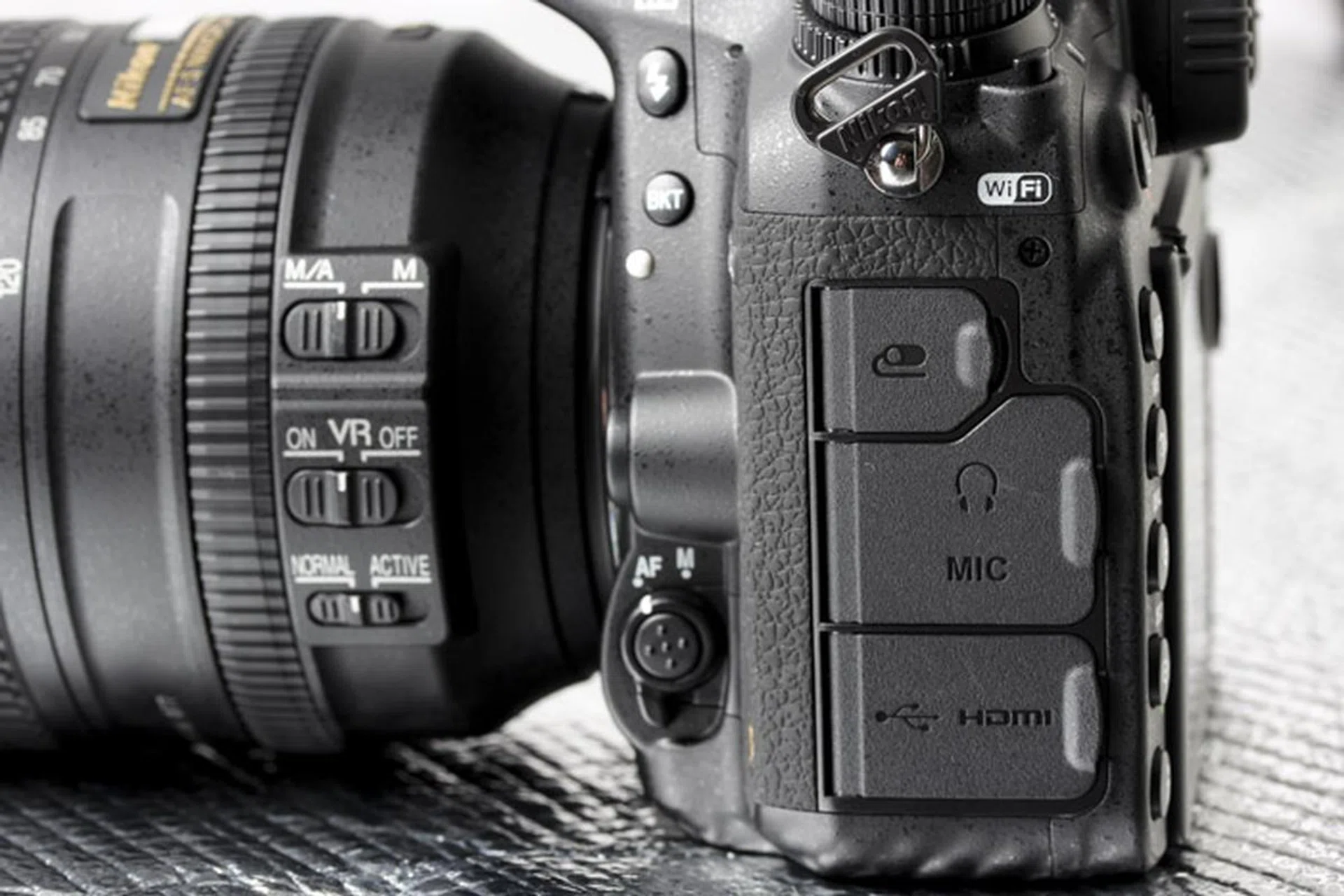 The bracketing button is now shifted to the front, while individual flaps for the remote and microphone/headphones for monitoring line the left side of the camera.