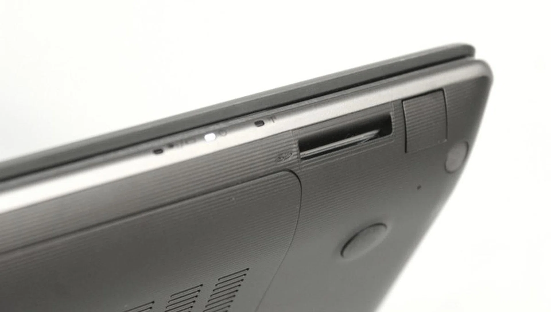The status LEDs are located at the front, so you can check the machine's condition without opening the lid. The SD card reader is in the front edge of the machine too. Next to that, you'll find a plastic patch, but when we pried it open it seemed like an access crevice for an optional feature that is unmarked; best to leave it alone. 
