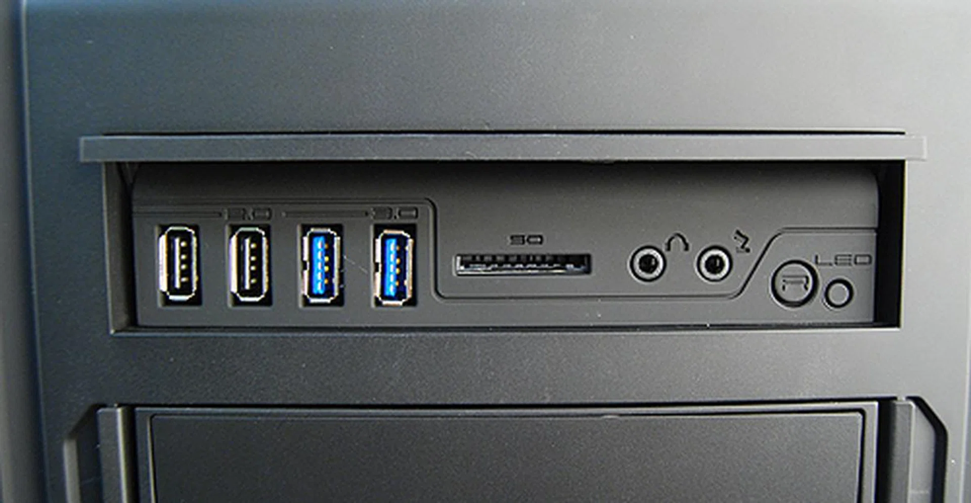 The front I/O ports are accessed by flipping open this panel near the top of the case. On that note, we must say that the opening mechanism is not the most elegant and is a bit awkward to use. Inside, there are two USB 2.0 ports, two USB 3.0 ports, a memory card reader, headphones and microphone jacks, an LED on/off button and a reset button.