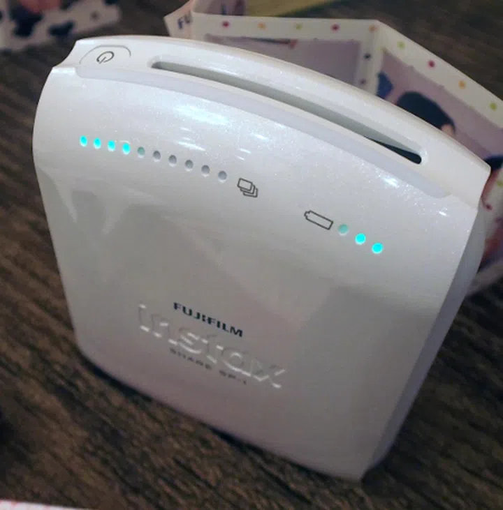 The lights on the left indicate how many sheets of Instax mini film are left in the Share Sp-1, while the lights on the right represent the battery level. 