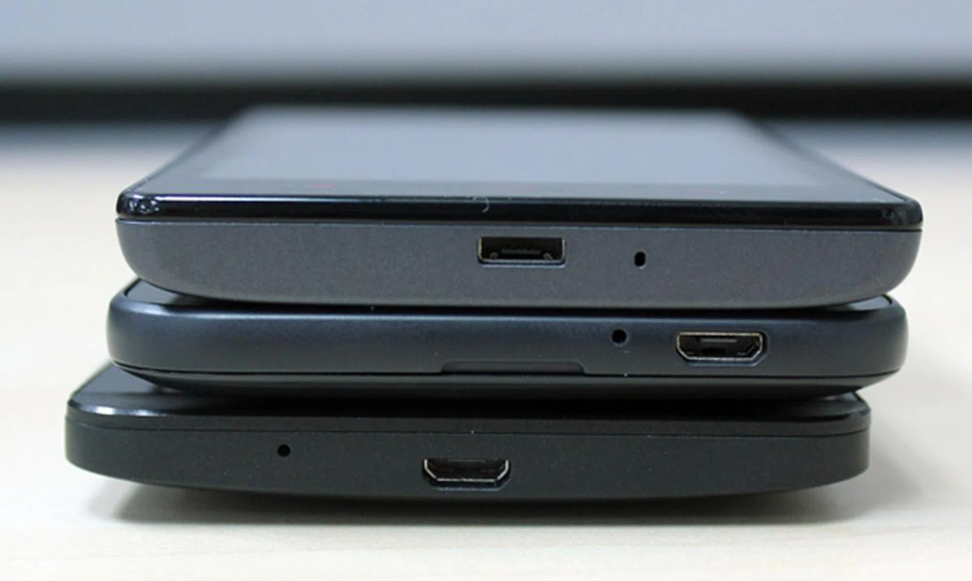 The bottom view of the three phones. <br> Top to bottom: Xiaomi Redmi 1S, HTC Desire 616 and ASUS ZenFone 5.
