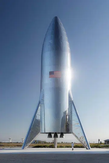 A gleaming Starship prototype stands at a SpaceX facility in Boca Chica Village, Texas. 