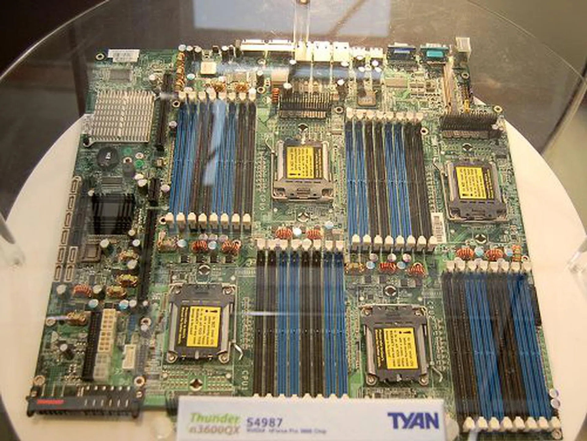  Probably the most powerful AMD server board offering from Tyan, the Thunder n3600QX motherboard takes in four Socket F AMD Opteron 8000 series processors. That equates to 8 processing cores in total and when AMD's native quad-core processors arrive, that number doubles to 16 processing cores! Based on the nForce Professional 3600 chipset, the board's features include 32 DIMM slots for a total of 128GB of registered DDR2-667 memory, one PCIe x16 slot, one HTX slot, one OPMA connector, four SATA 3Gbps with RAID, eight SAS connectors with RAID, dual Gigabit Ethernet, one Infiniband port and integrates an ATI ES1000 graphics controller with 32MB memory.  