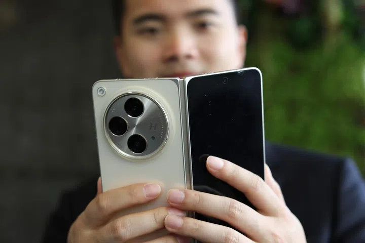 Zhou Yibao with OPPO’s latest product, the book-style Find N3. Credit: OPPO