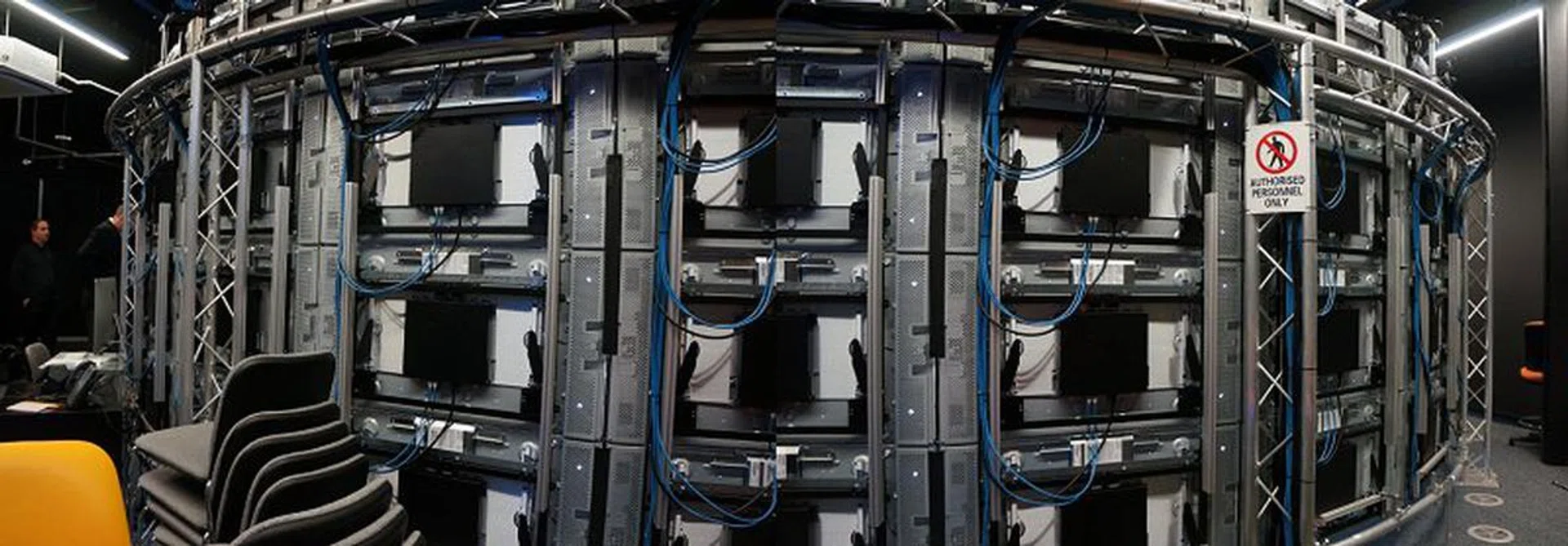 Around the back, this is what the CAVE2 infrastructure is made of – numerous screens and a 10Gbps high speed network fabric linking everything to processing nodes.