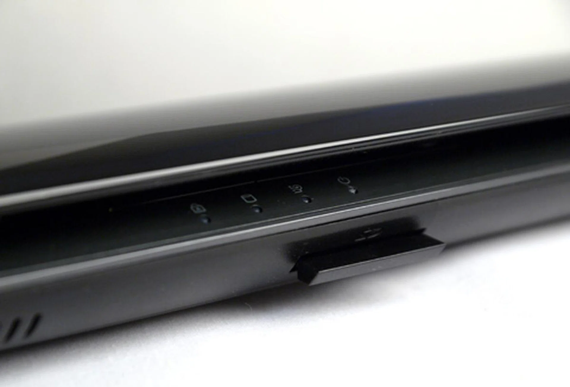 The four status LEDs remain visible with the lid closed. Right below them sits a 4-in-1 card reader, protected by a slot-in dust cover. Operationally, this notebook is as quiet as a mouse.