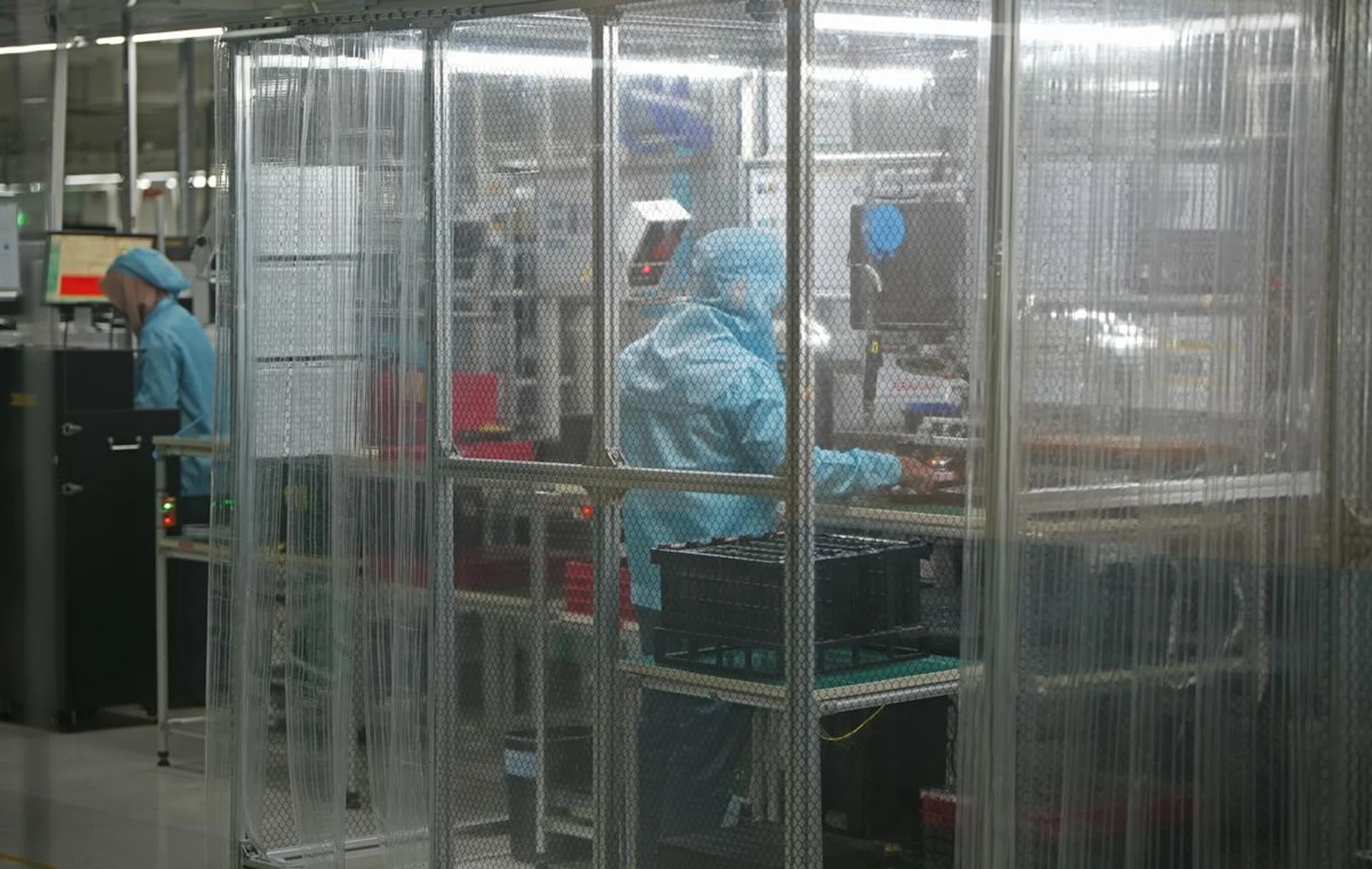 Assembly worker installing sensitive OPPO phone components in a dust-controlled environment. Photo: OPPO.