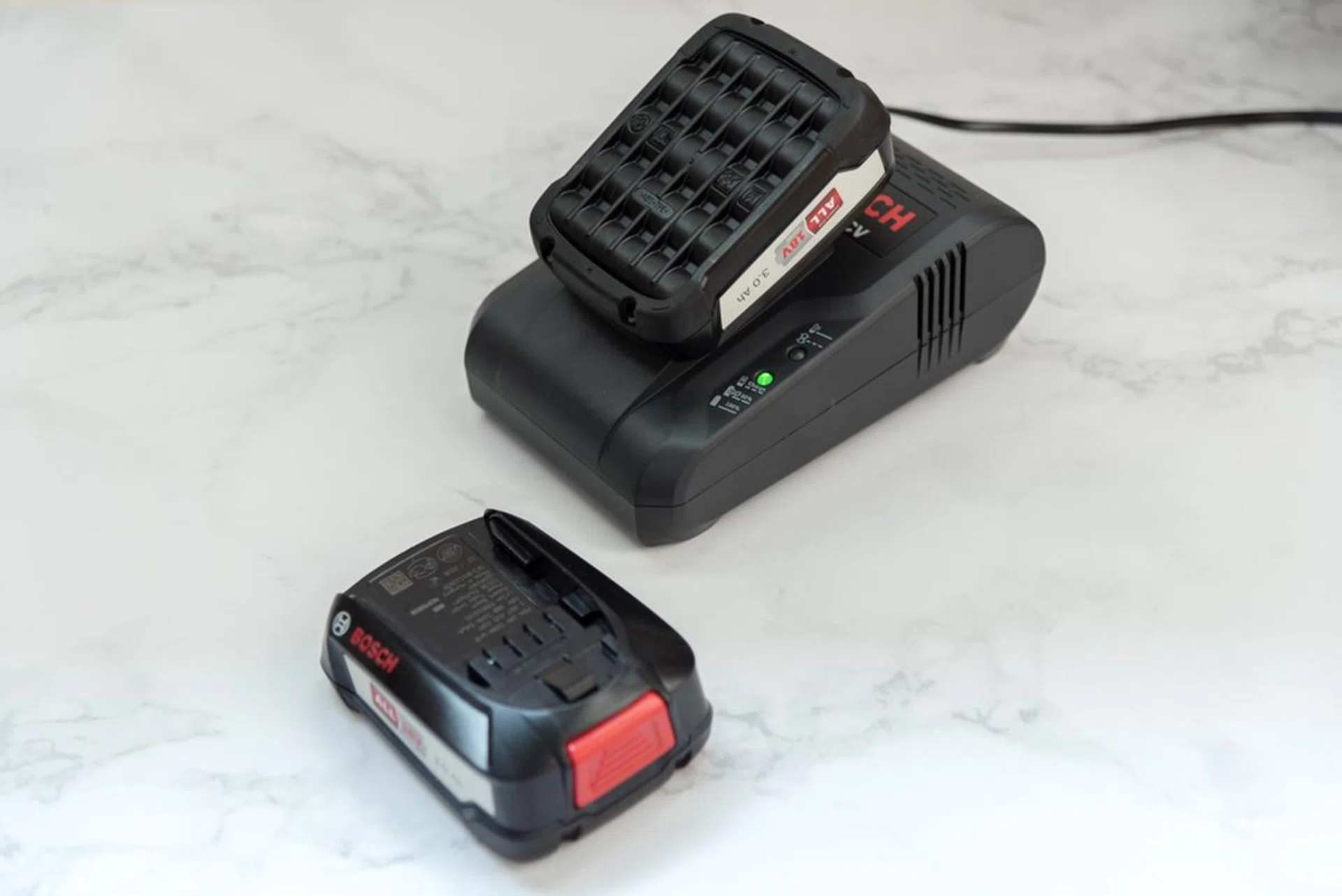 The battery charger is big, thick, and makes fan sounds.