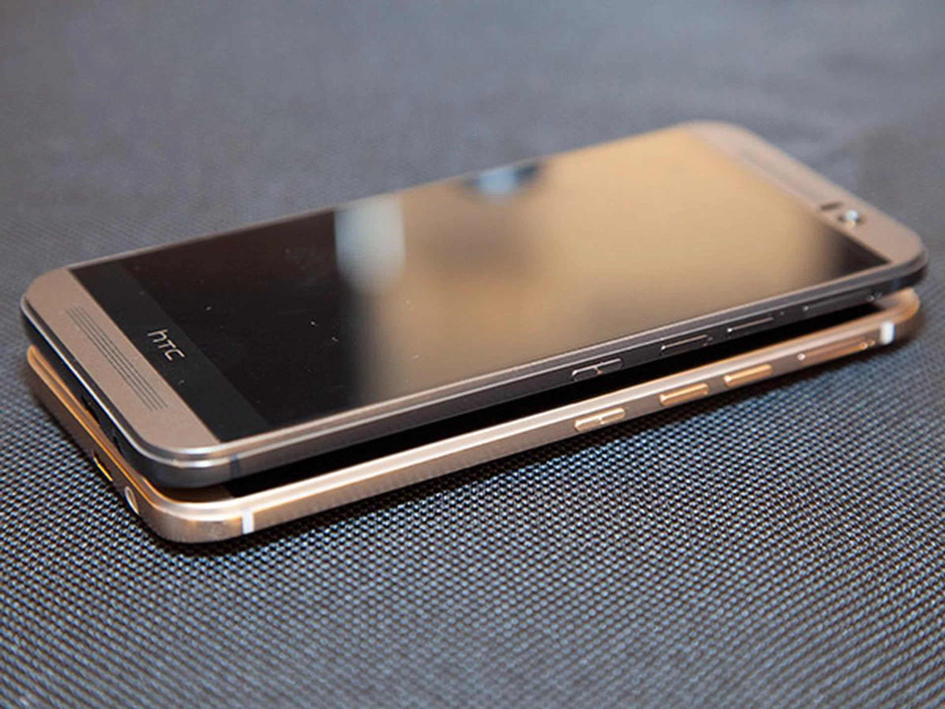 The gold on silver two-tone design is quite subtle and is only visible when viewed from the sides. Also, you can see here that the power button has now moved to the right flank of the phone. The power button is differentiated from the volume buttons by its concentric circle texture. In addition, HTC has done away with the volume rocker button in the M7 and M8, and replaced it with two discrete buttons.