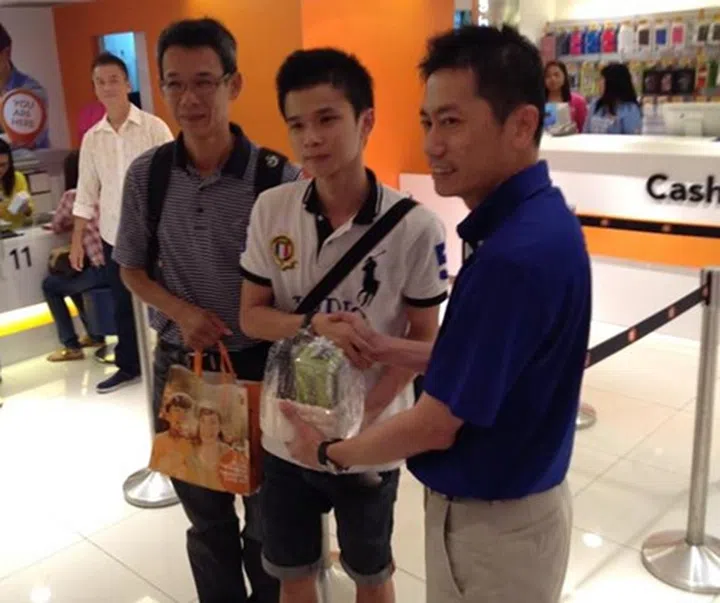 Yip (in white polo tee) queued a day earlier so that he could get the gold iPhone 5S. Joseph Lok (right), General Manager of M1 Shop Paragon congratulated him on his purchase.