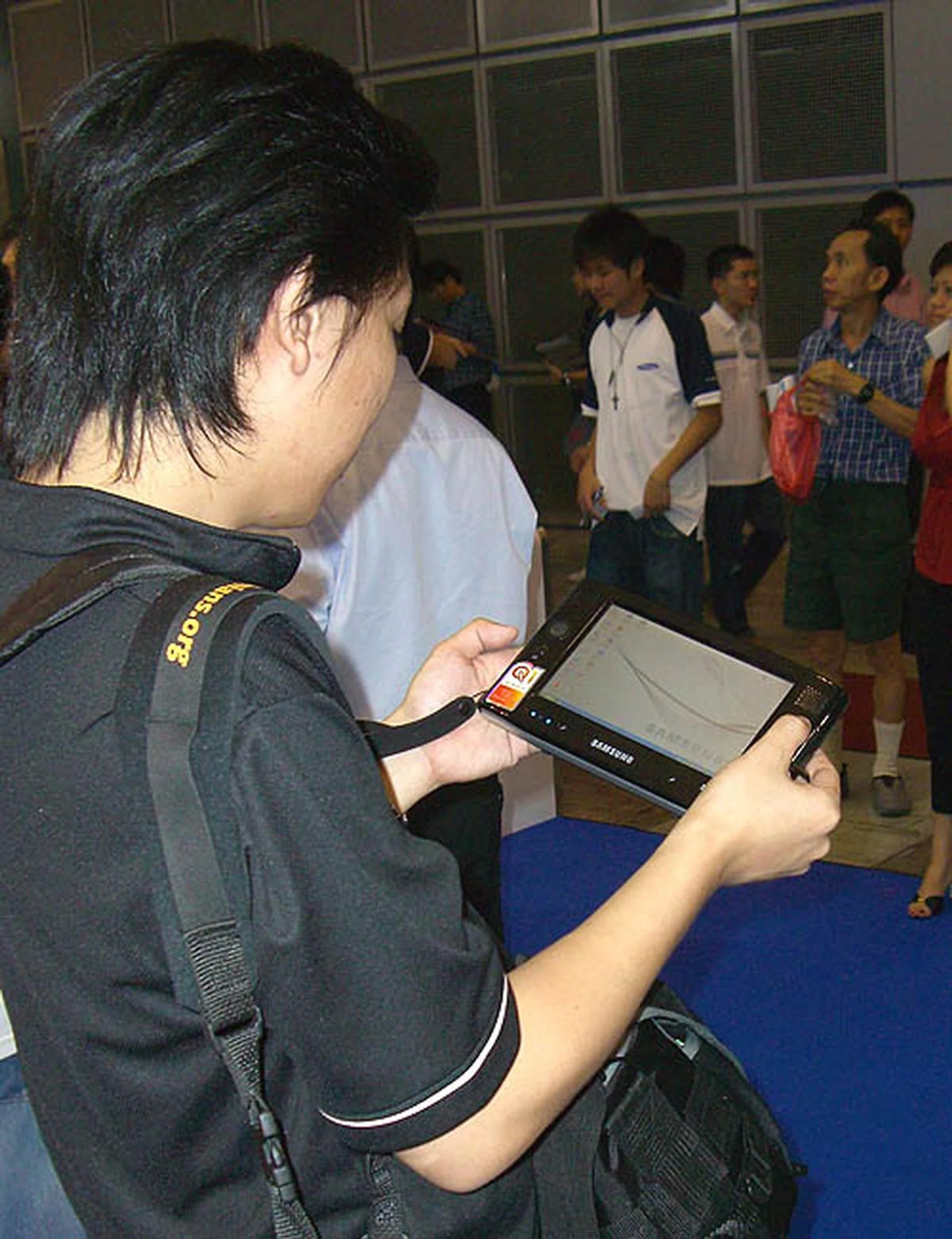 Is that a babe we see over there? No, that's just our colleague playing with a babelicious Ultra Mobile PC from Samsung. It's not available locally yet till later this year but it sure looks alluring with its petite form factor. 