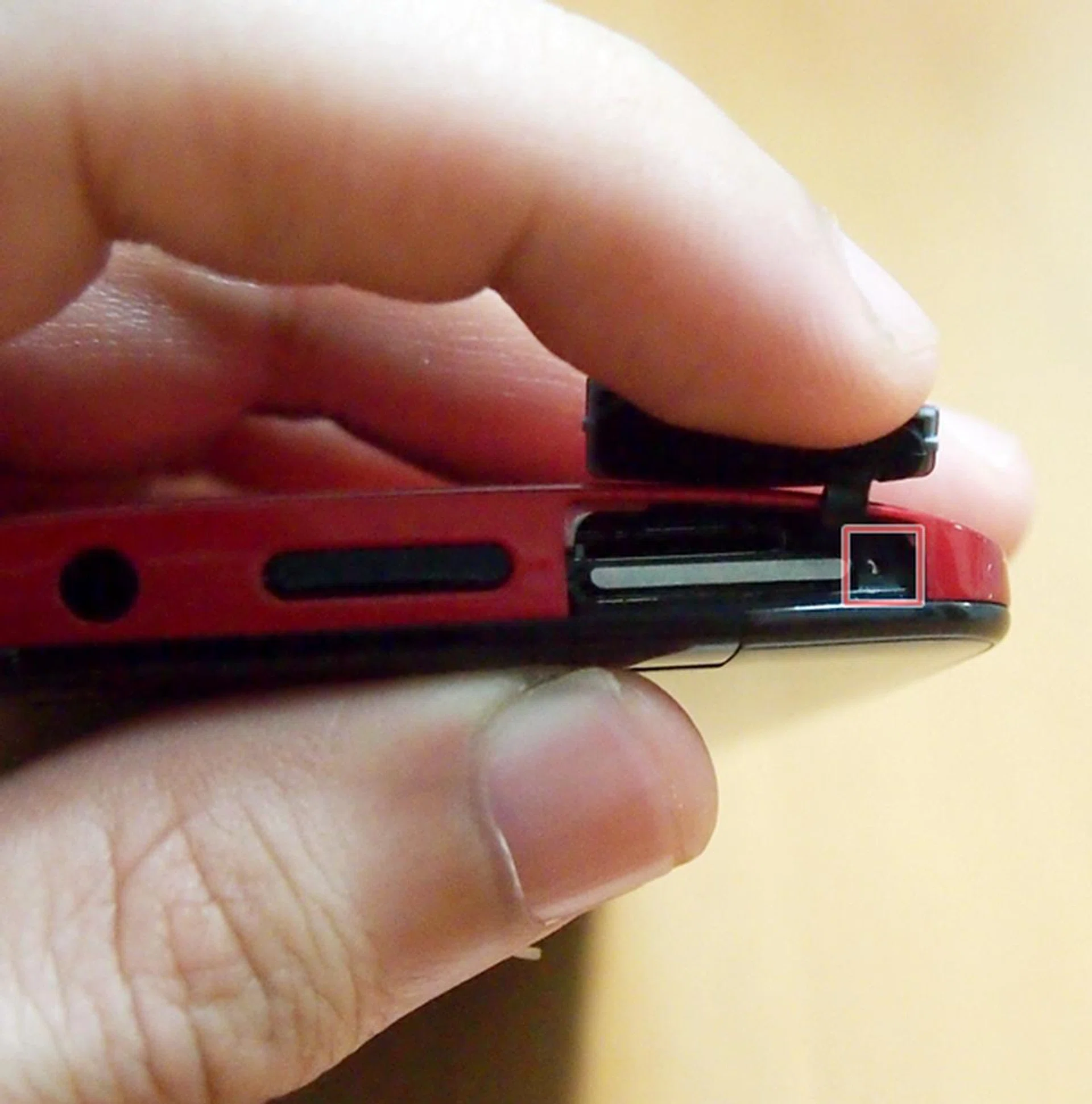 You either use your fingernail to pull out the micro-SIM card tray or use a pin to eject it out via the small hole on the right.