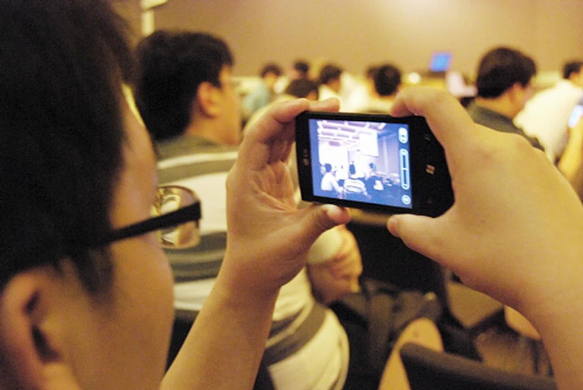 One of the many participants testing out the LG Optimus 7's camera. The phone itself is equipped with a 5-megapixel camera  that comes with LED flash and auto-focus capabilities.