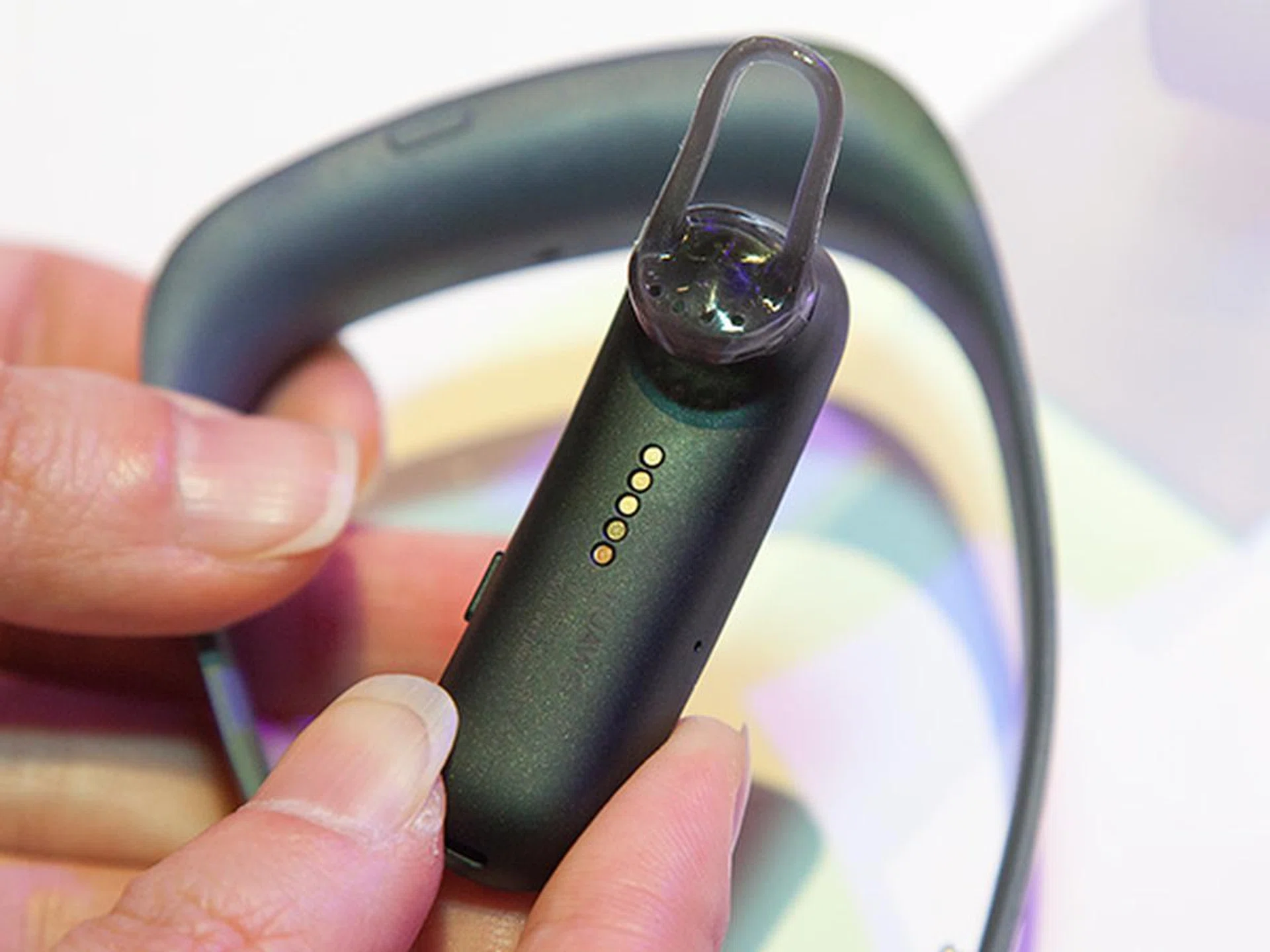 Pins located underneath the earpiece connects with the pogo pins on the band. Without the band, you'll not be able to charge the earpiece.