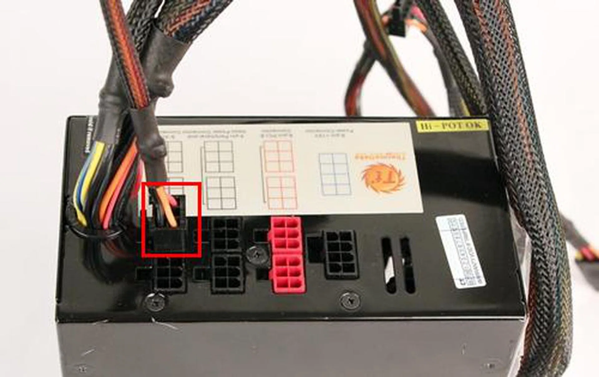 Our usual PSU that has been stripped of all its modular power cables, save the one that is highlighted with the red frame. The bundled power cables to its left are not removable as they are the bare minimum required to power the system.