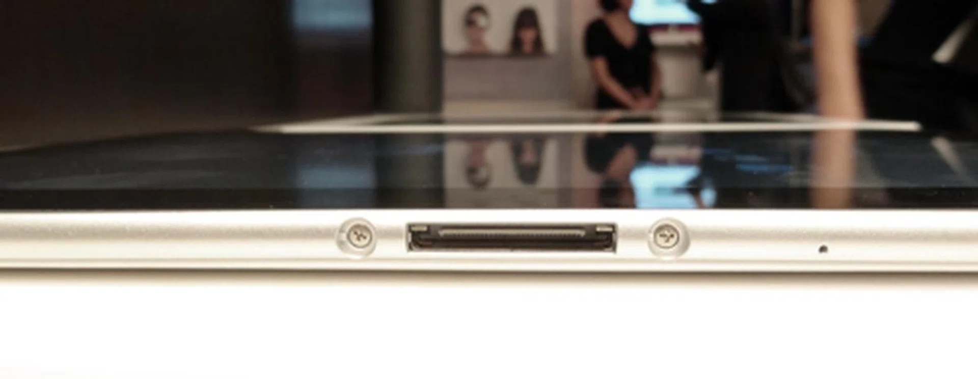 A charging port sits at the bottom of the tablet.