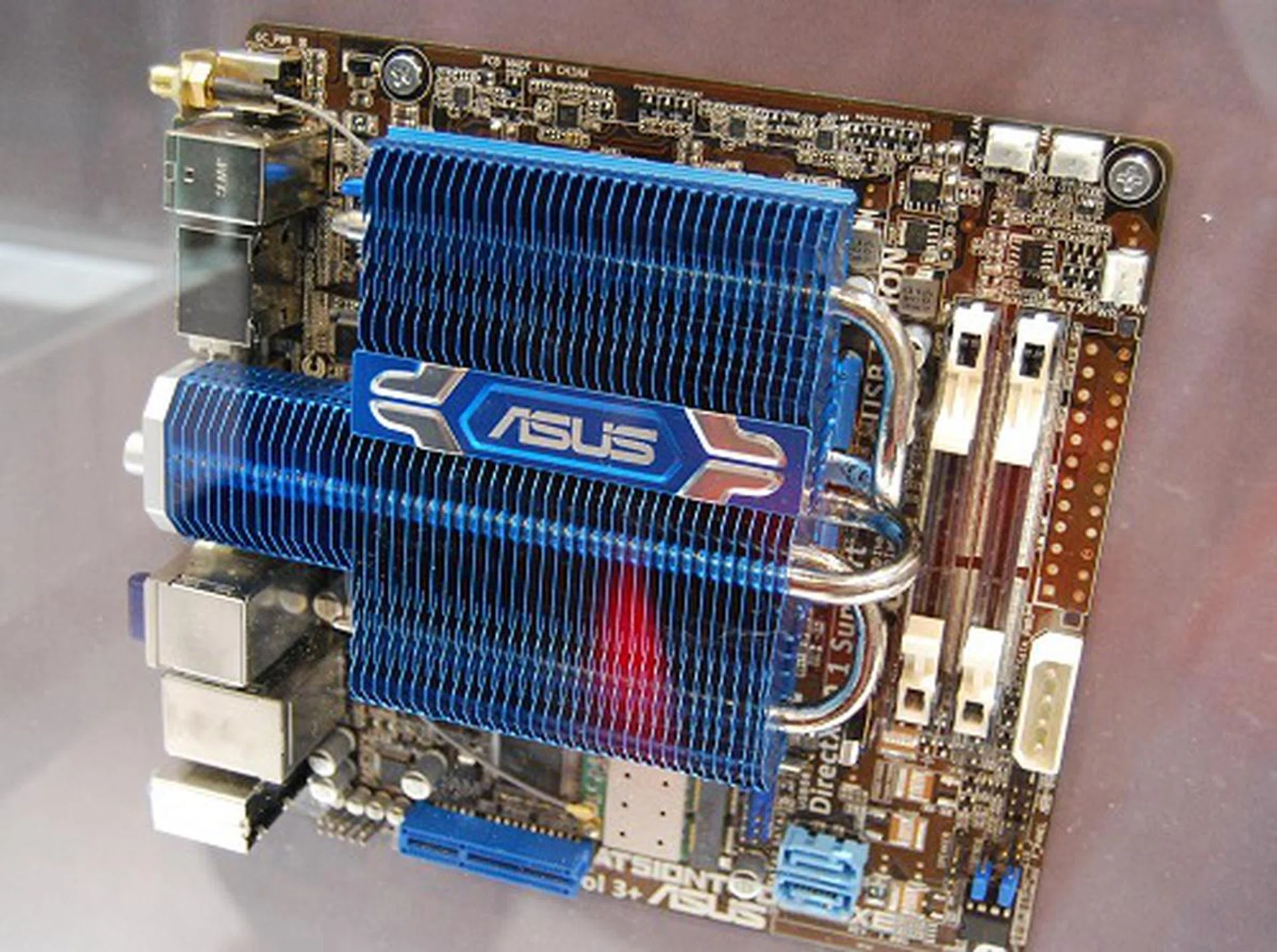 This fully self-contained and cooled motherboard is the ASUS AT5IONT-I Deluxe. It's supposedly based on the upcoming Intel Atom D425 or D525 processor paired with the existing Intel NM10 chipset. Since it's using the newer Atom processors, it supports DDR3-800, but only of the SO-DIMM variety because the board is rather cramped. It is also supplemented by NVIDIA's next generation Ion graphics engine and it even claims to have an integrated PSU on the board - eliminating any further adapters. If all of these specs pass are true in the final board revision, it's truly a self-contained board that is fit to take the HTPC crown.