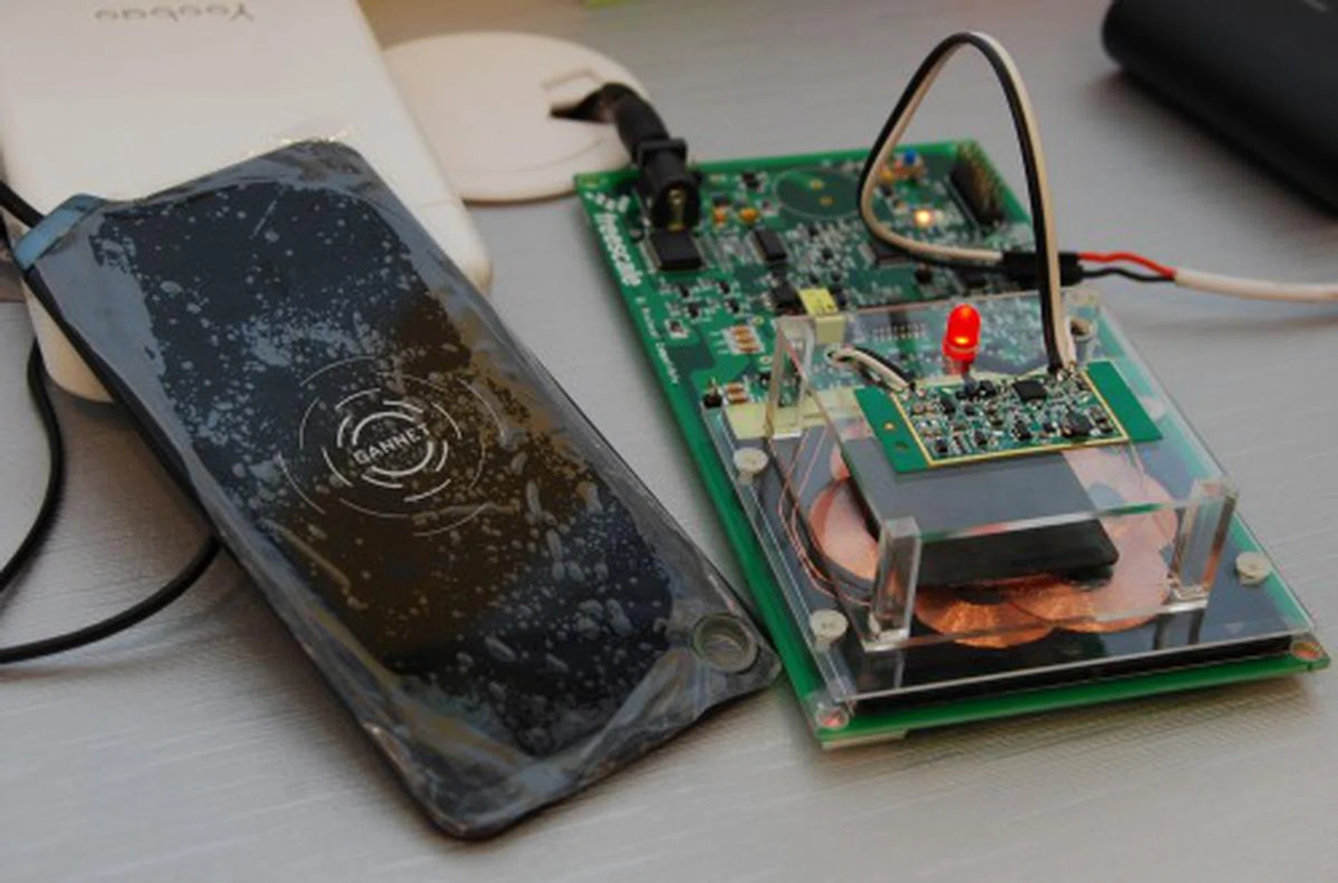 The red light emitting diode on top of the receiver unit indicates successful charging is established. At the moment transmission efficiency is about 80% and is a figure the consortium is working together to improve upon. The black charging plate on the left is an indication of how an actual implementation can condense what’s seen on the reference design.