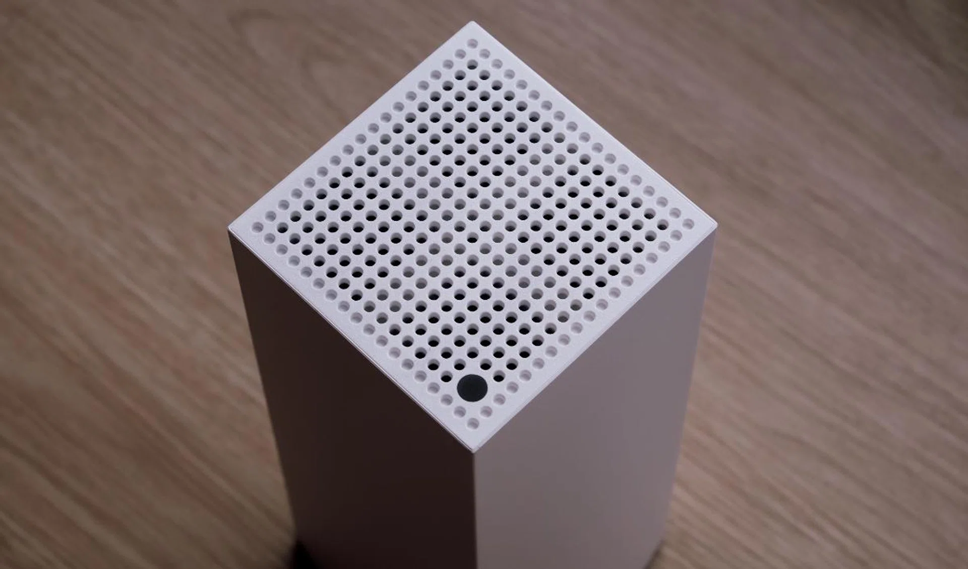 Vents at the top help cool the router down. At a corner is a small LED status indicator.