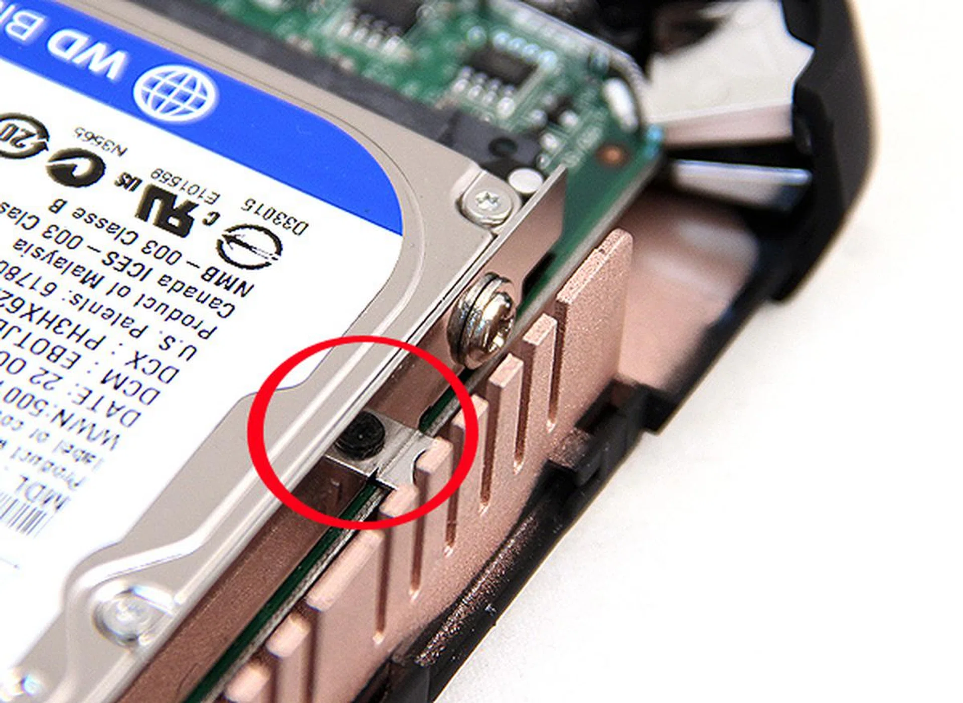 This is because on the opposite side, the screw securing the drive to the cage is inaccessible because of the heatsink. Therefore, one needs to remove the entire cage by removing the highlighted black screws before the drive can be freed. As you can see, the silver screw securing the drive to the hard disk cage is unreachable. Incidentally, because of the position of the heatsink, re-securing the drive cage proved to be challenging too. We highly recommend the use of magnetic screwdrivers in this endeavor. 