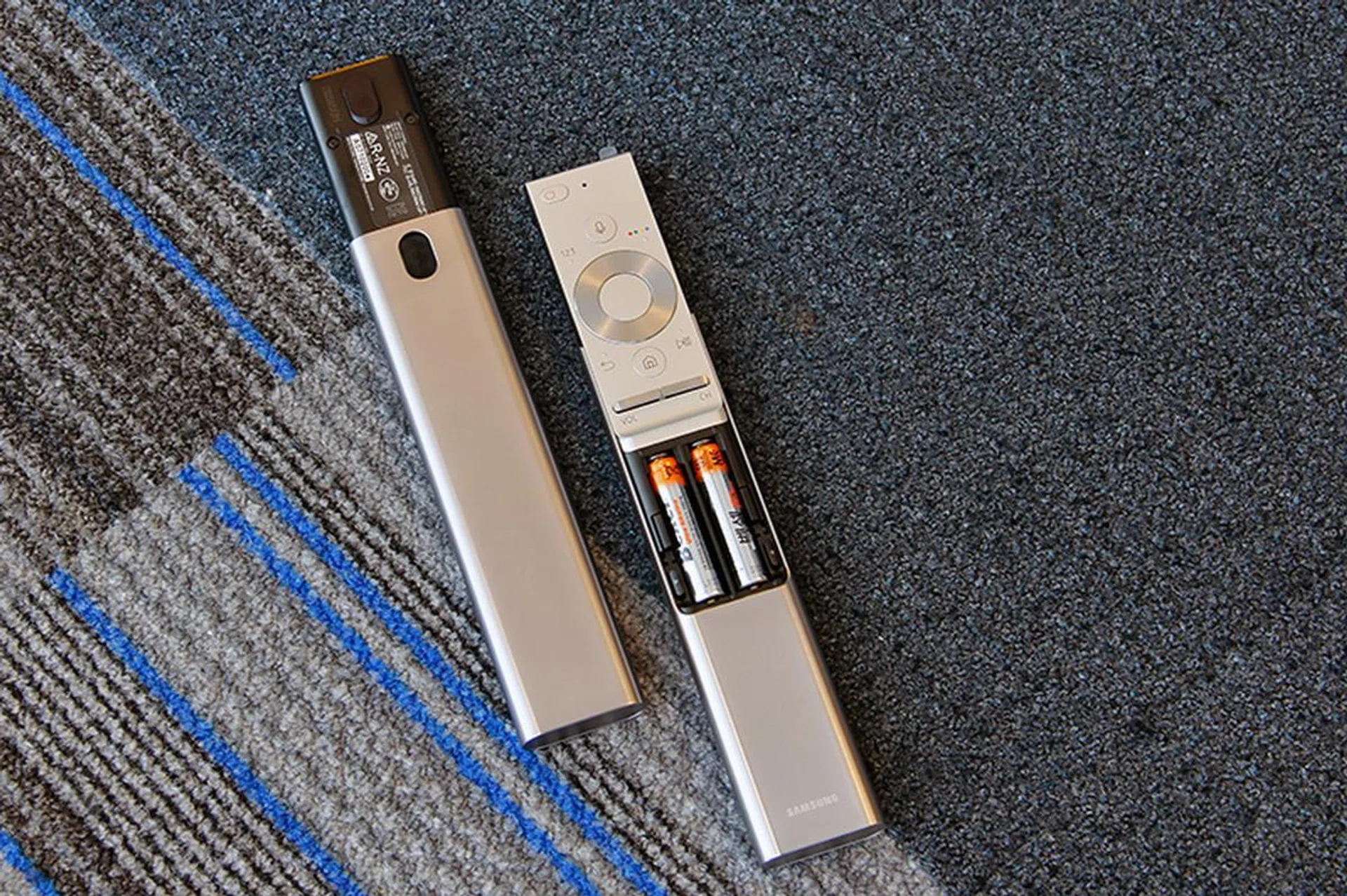 The smart remote's batteries pop out from the front.