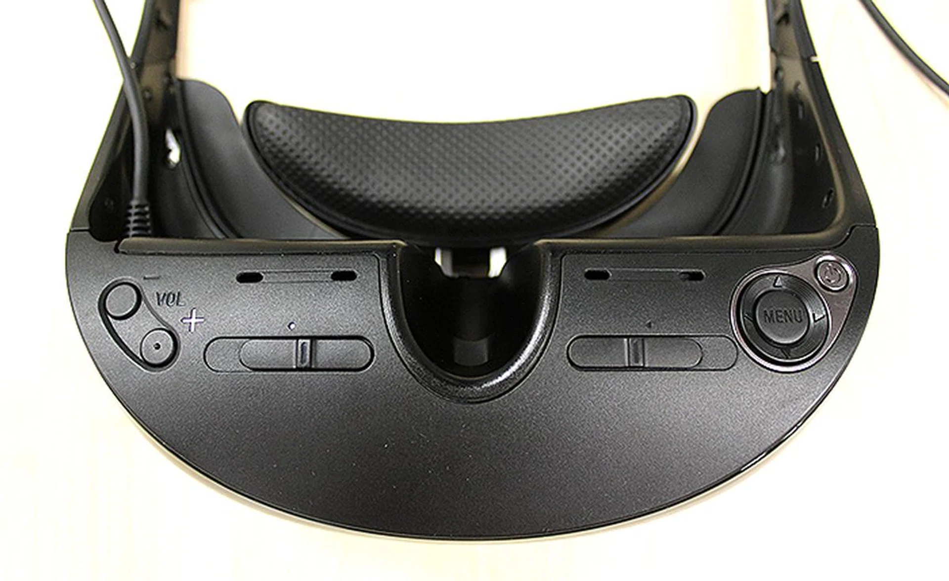 On the underside of the visor, you will find the volume controls and menu button for adjusting the display. In the middle are two sliders which adjust the lenses' position.