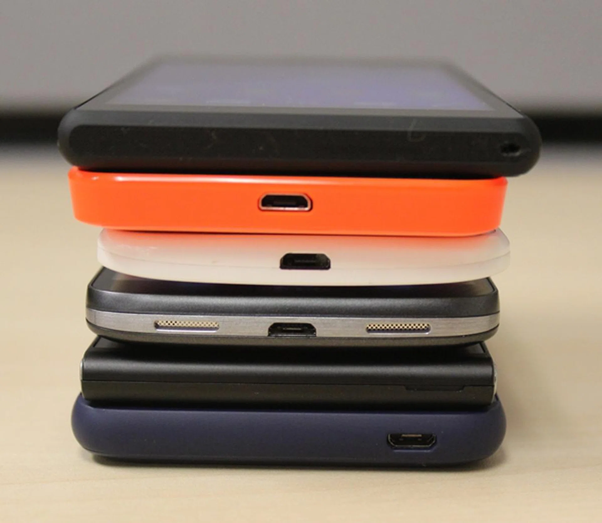 The bottom view of the six phones. <br> Bottom to top: HTC Desire 610, Huawei Ascend G6 4G, LG G2 Mini LTE, Motorola Moto X, Nokia Lumia 635 and the Sony Xperia M2.