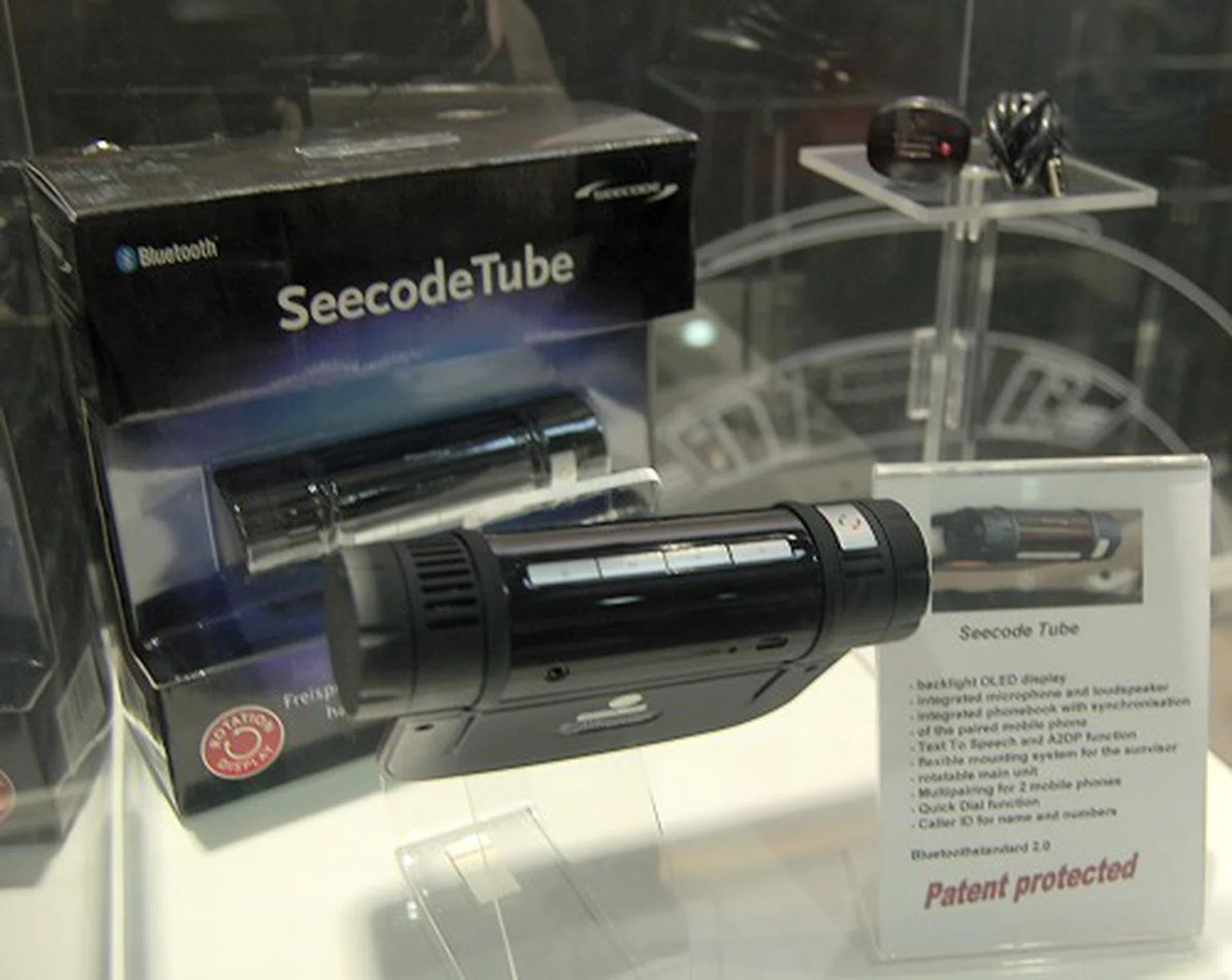  This is the Seecode Tube. With its unique rotatable display, it can mount on your car's sun visor and you can read the display comfortably no matter the visor's position. What's more, it can also sync with your phone's phonebook to make outgoing calls without fiddling with your phone (stores up to 300 numbers). Uses an OLED screen, integrates a loudspeaker, battery, microphone and has A2DP and Caller-ID functionality.  