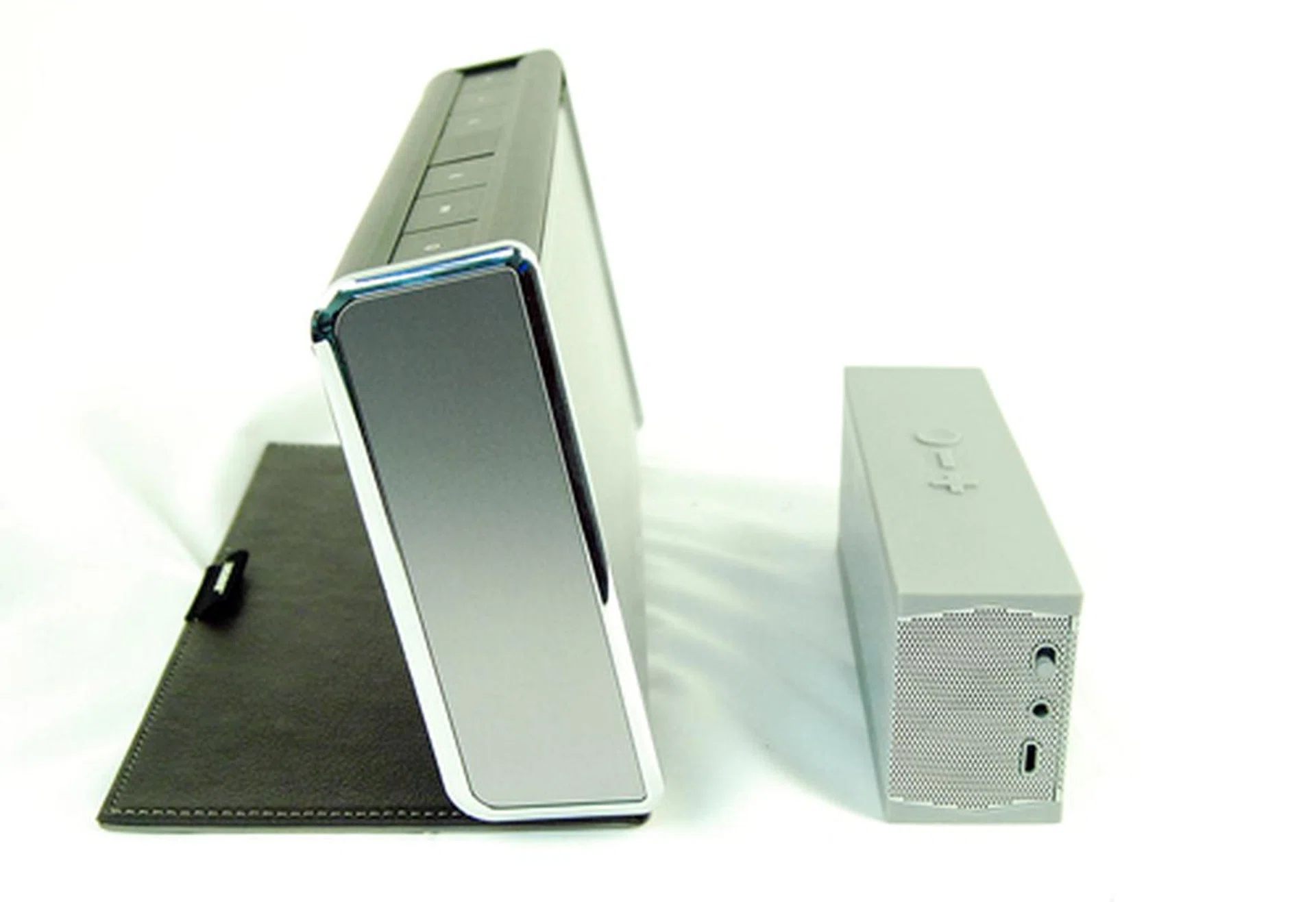 A side by side comparison of the Bose SoundLink and the Jawbone Jambox. The difference in size is extremely evident.