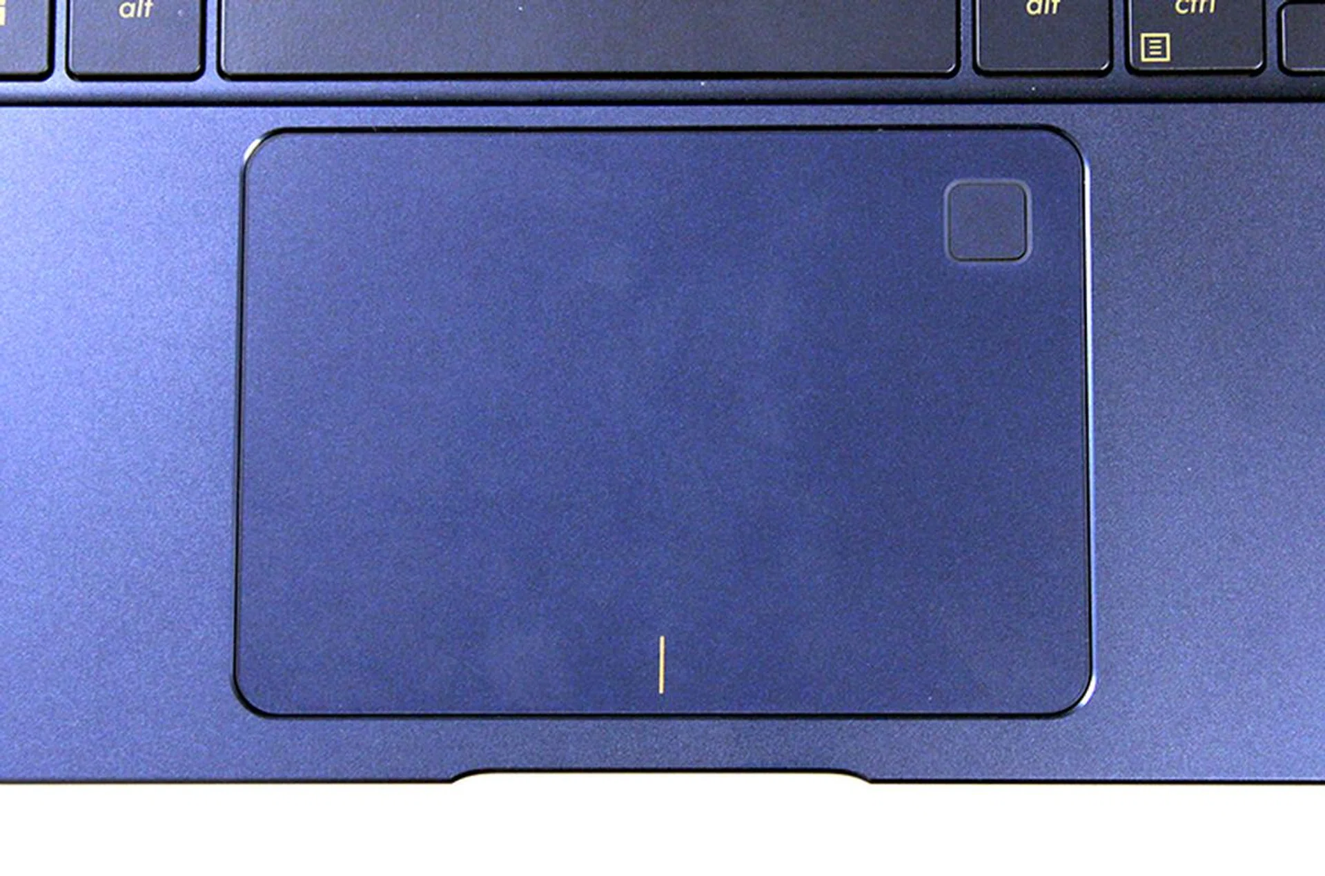 The trackpad is expansive and has a built-in fingerprint sensor in the top right corner.