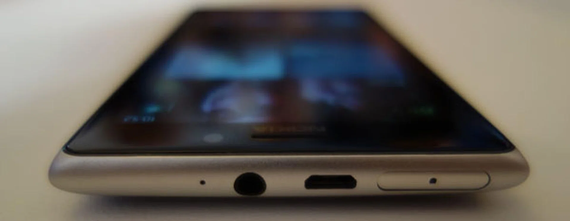 Top edge view, from left to right: Microphone, headphones jack, micro-USB connector (for charging/syncing), microSIM card slot.