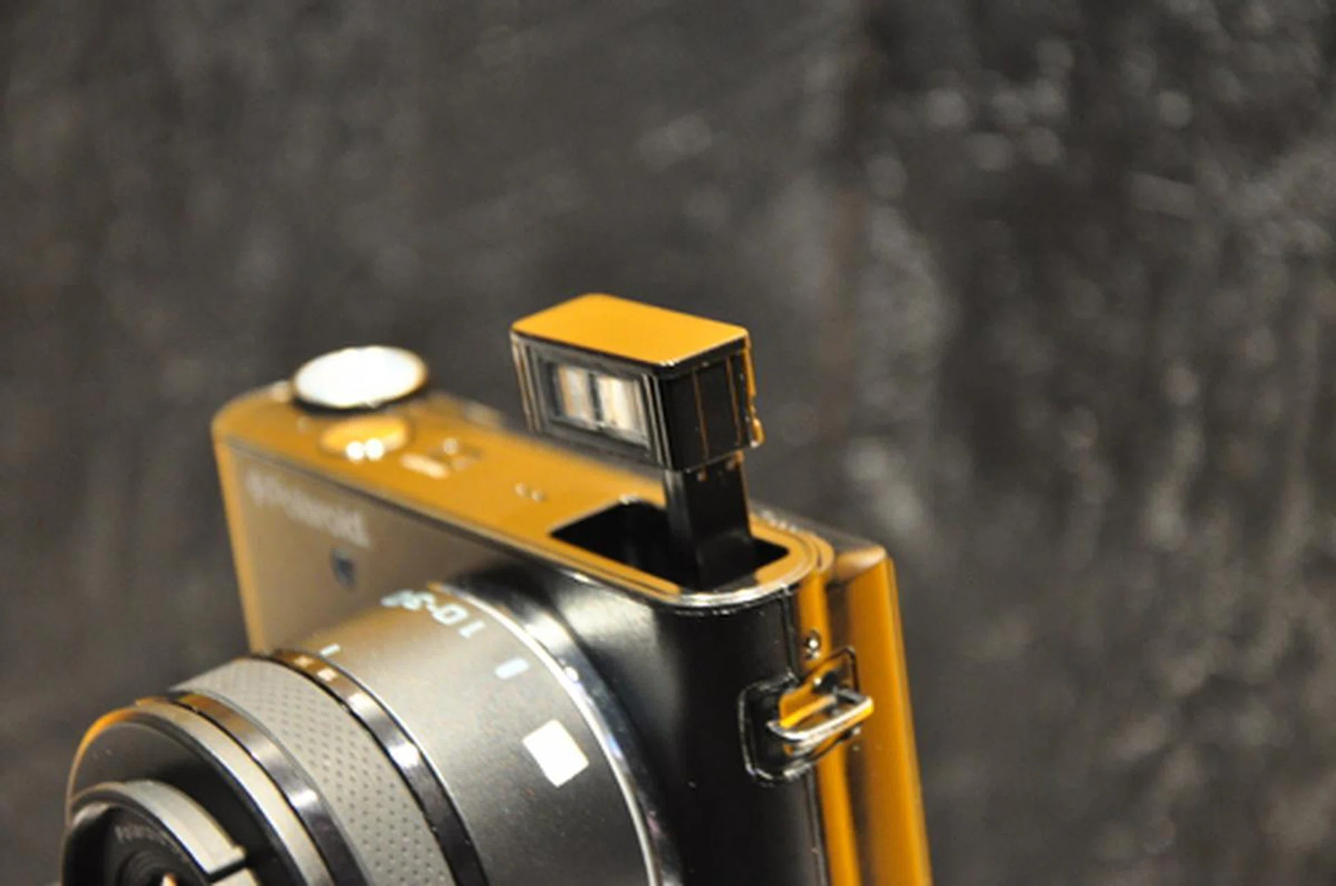 A tiny, almost indiscernable switch behind the concealed flash allows users to pop it up. Much to our displeasure, the flash unit feels and looks a little too flimsy for our liking. 