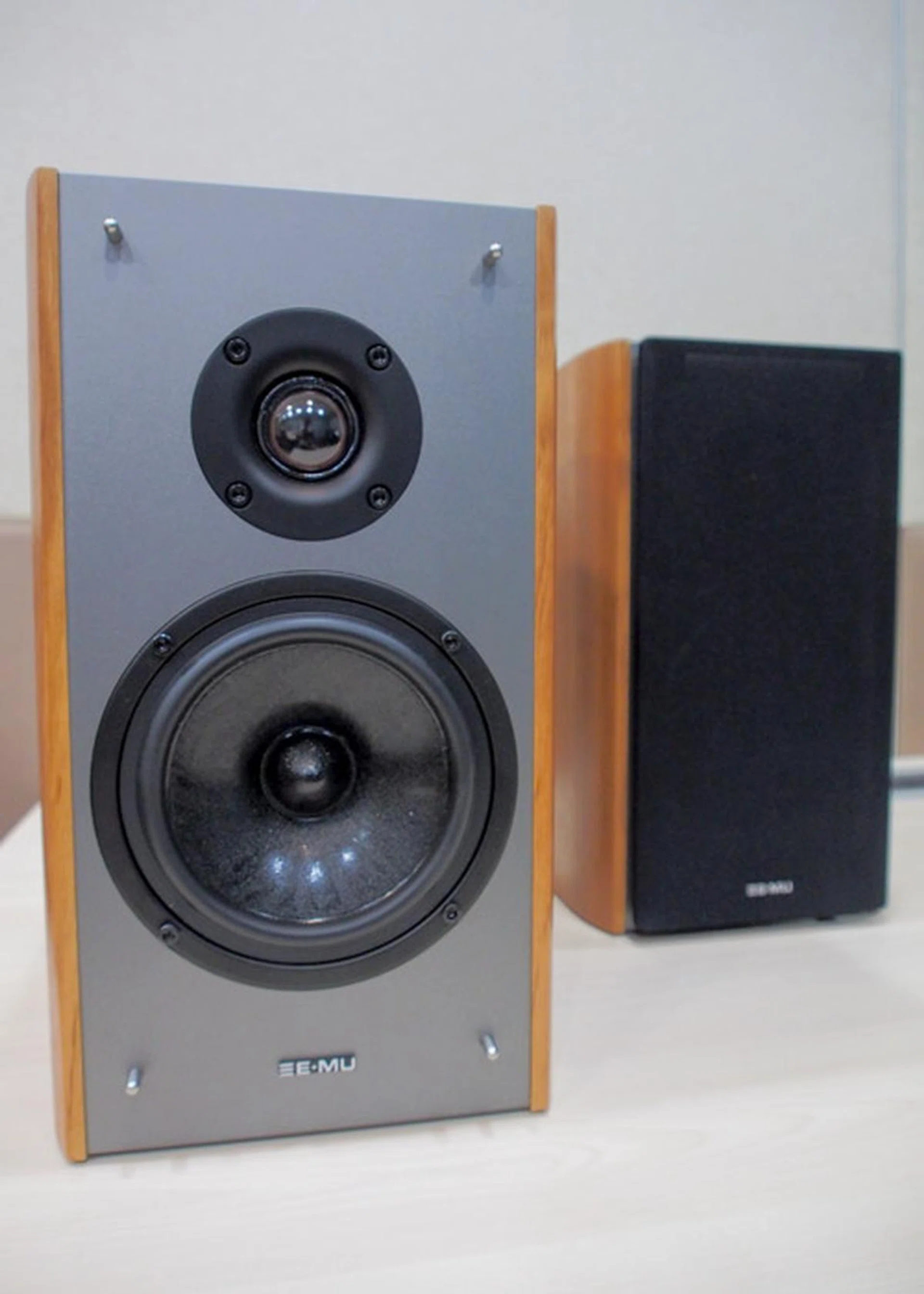 The E-MU XM7 in brown wood grain with metallic grey finish.