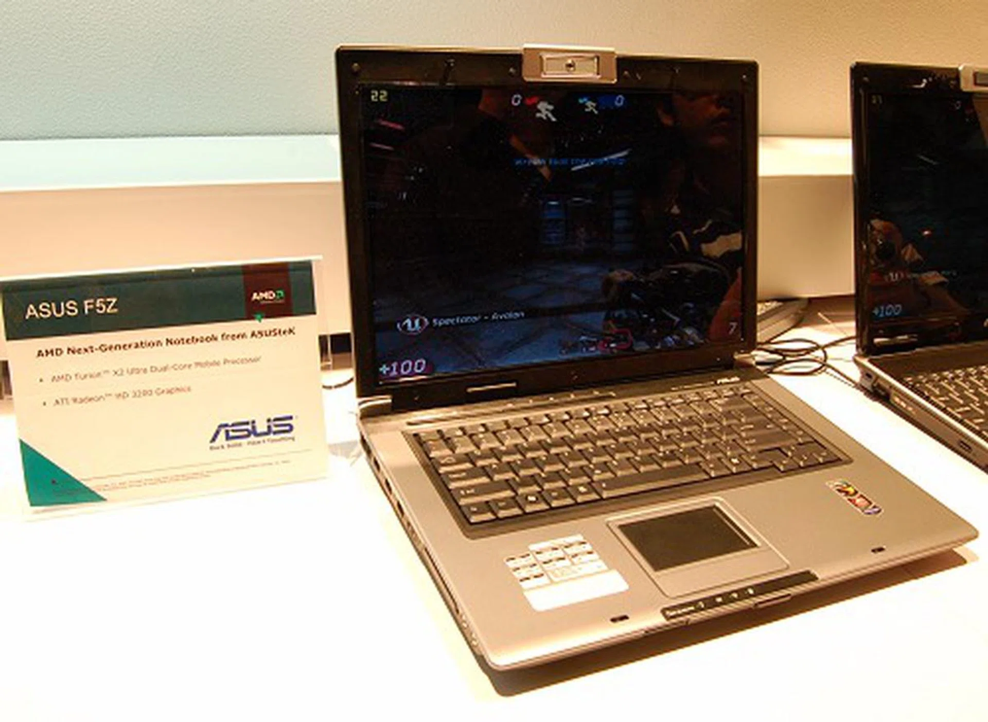 Next up, we have two similar ASUS notebooks to showcase the difference that Hybrid graphics can make. In this photo, we've here an ASUS F5Z notebook that's using the basic Puma platform, thus running off the Radeon HD 3200 graphics and running the UT3 benchmark. It averages around the 30FPS mark, but often gets to the twenties range in more taxing segments as seen on screen.