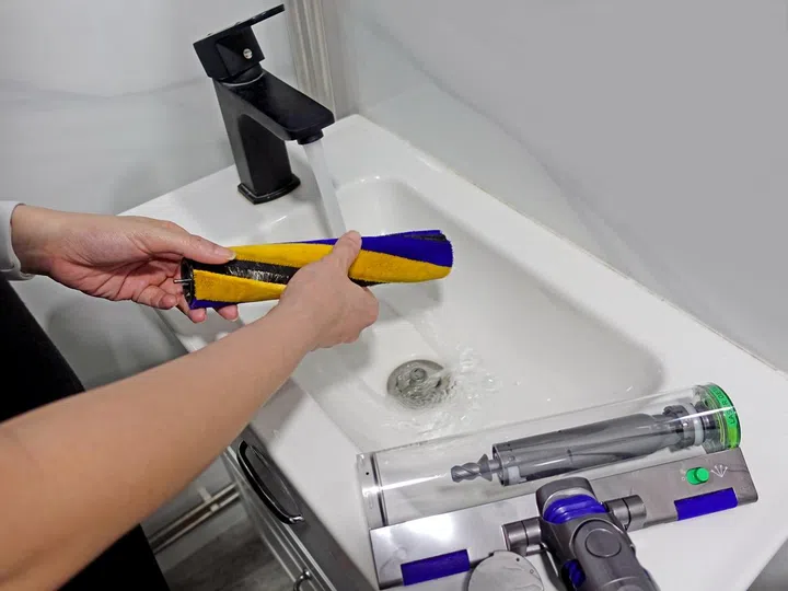 Here's an example of washing the brush bar from the main cleaning head under running tap water. (Image source: HardwareZone)