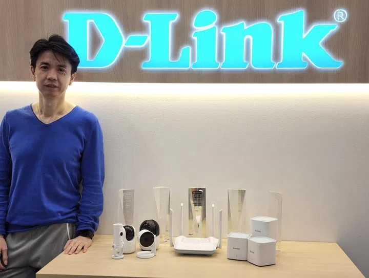 Jonathan Quek, Product Director at D-Link posing with their Tech Award trophies they've garnered over the years, their top IP Cameras and their new range of Eagle Pro whole-home networking solution.