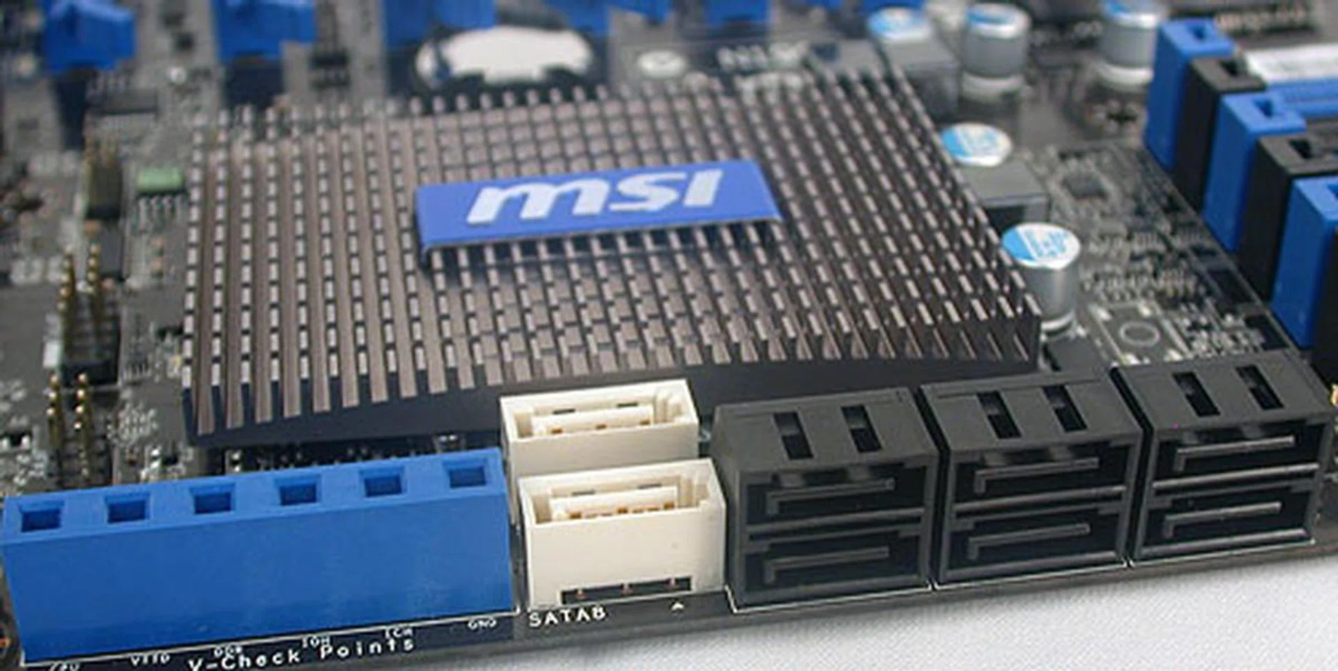The black SATA ports are 3Gbps versions from the Southbridge. The white ports are the newer SATA 6Gbps ones from a Marvell 9128 controller. Finally, there's a set of voltage check points here for those who wish to rely on their own tools.